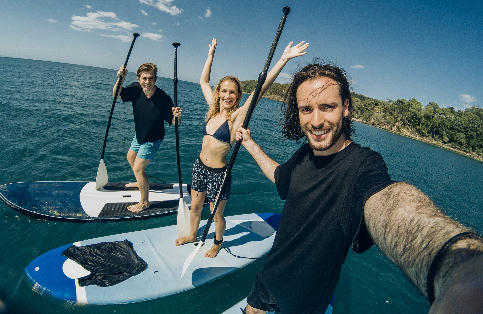 Three friends taking a selfie while paddle boarding on the Sunshine Coast Three friends taking a selfie while paddle boarding on the Sunshine Coast