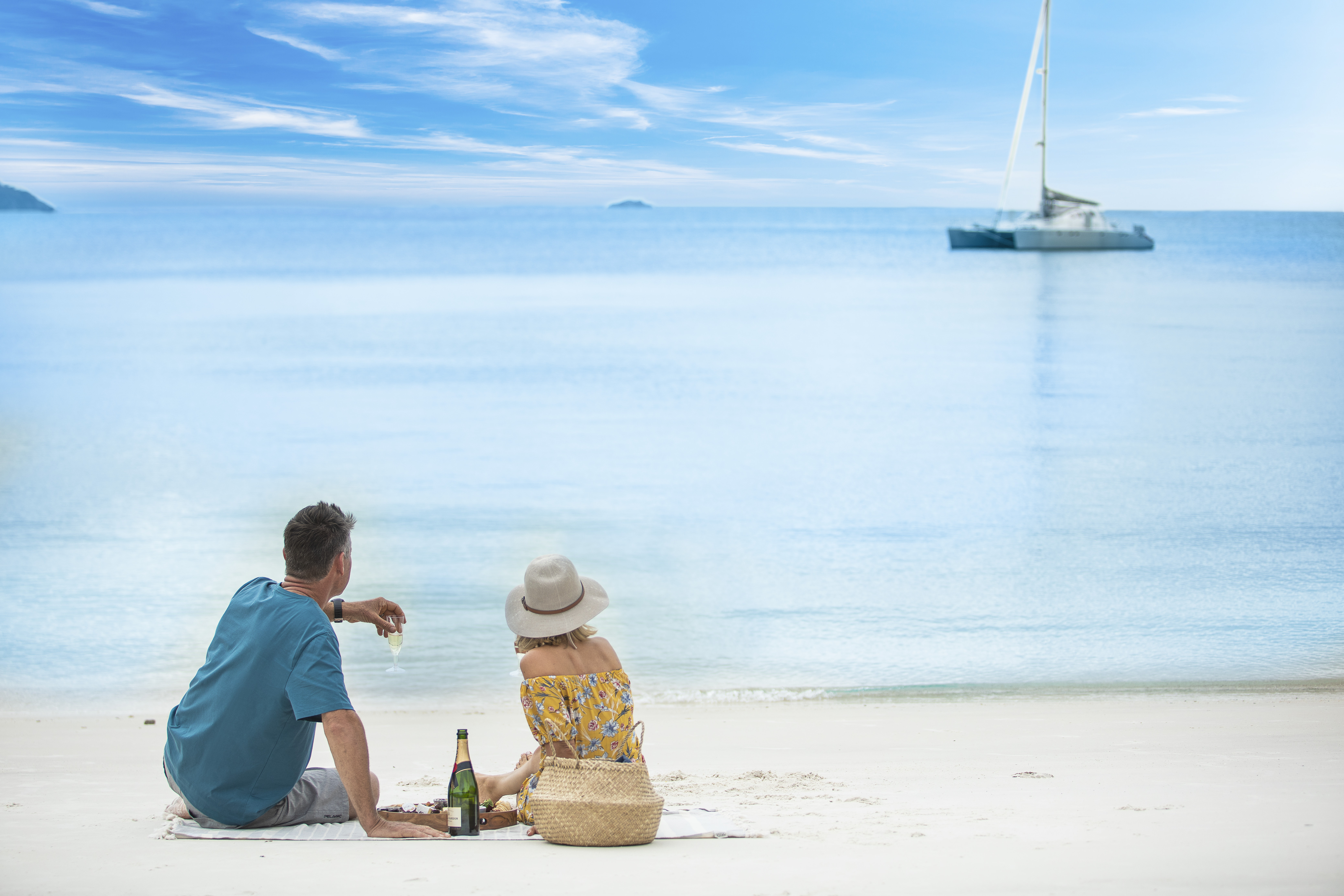 Couple enjoying picnic on the beach | World Oceans Day Queensland Couple enjoying picnic on the beach | World Oceans Day Queensland