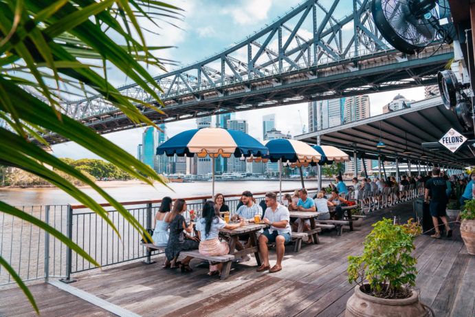 A group of friends sitting around a table at Felons Brewing Co at Howard Smith Wharves in Brisbane A group of friends sitting around a table at Felons Brewing Co at Howard Smith Wharves in Brisbane