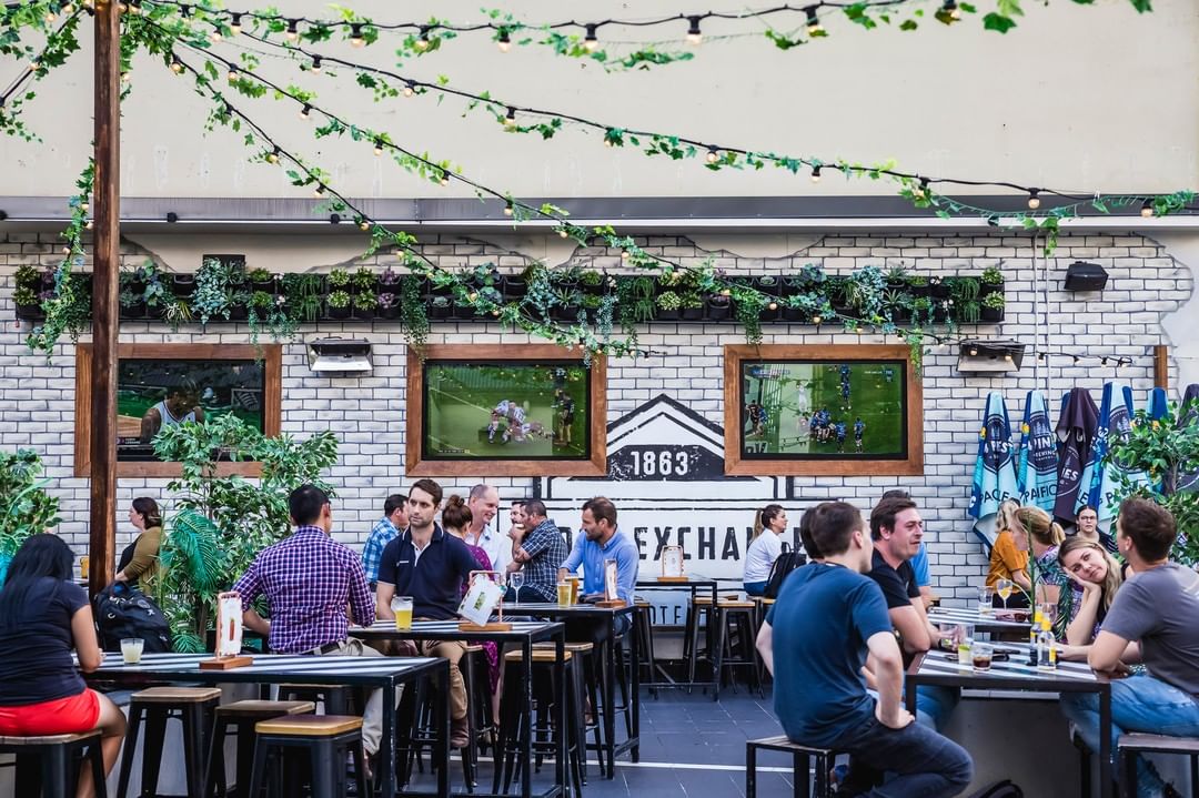 Busy rooftop bar with tables full of patrons