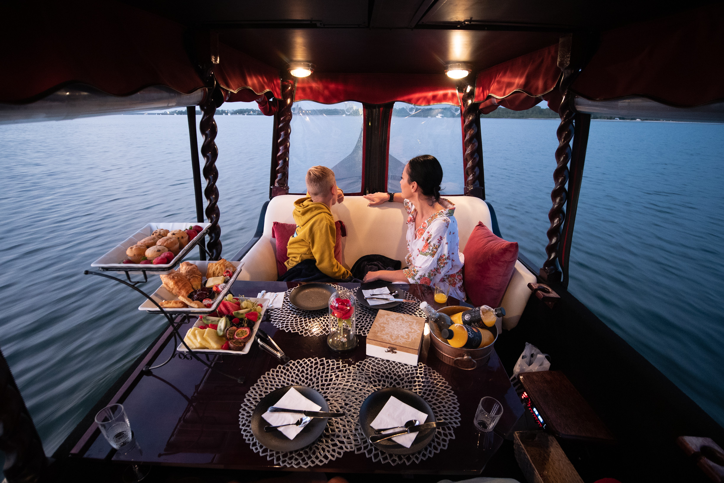 Mother and son enjoying a sunrise cruise, with Bribie Island Gondola at dusk Mother and son enjoying a sunrise cruise, with Bribie Island Gondola at dusk