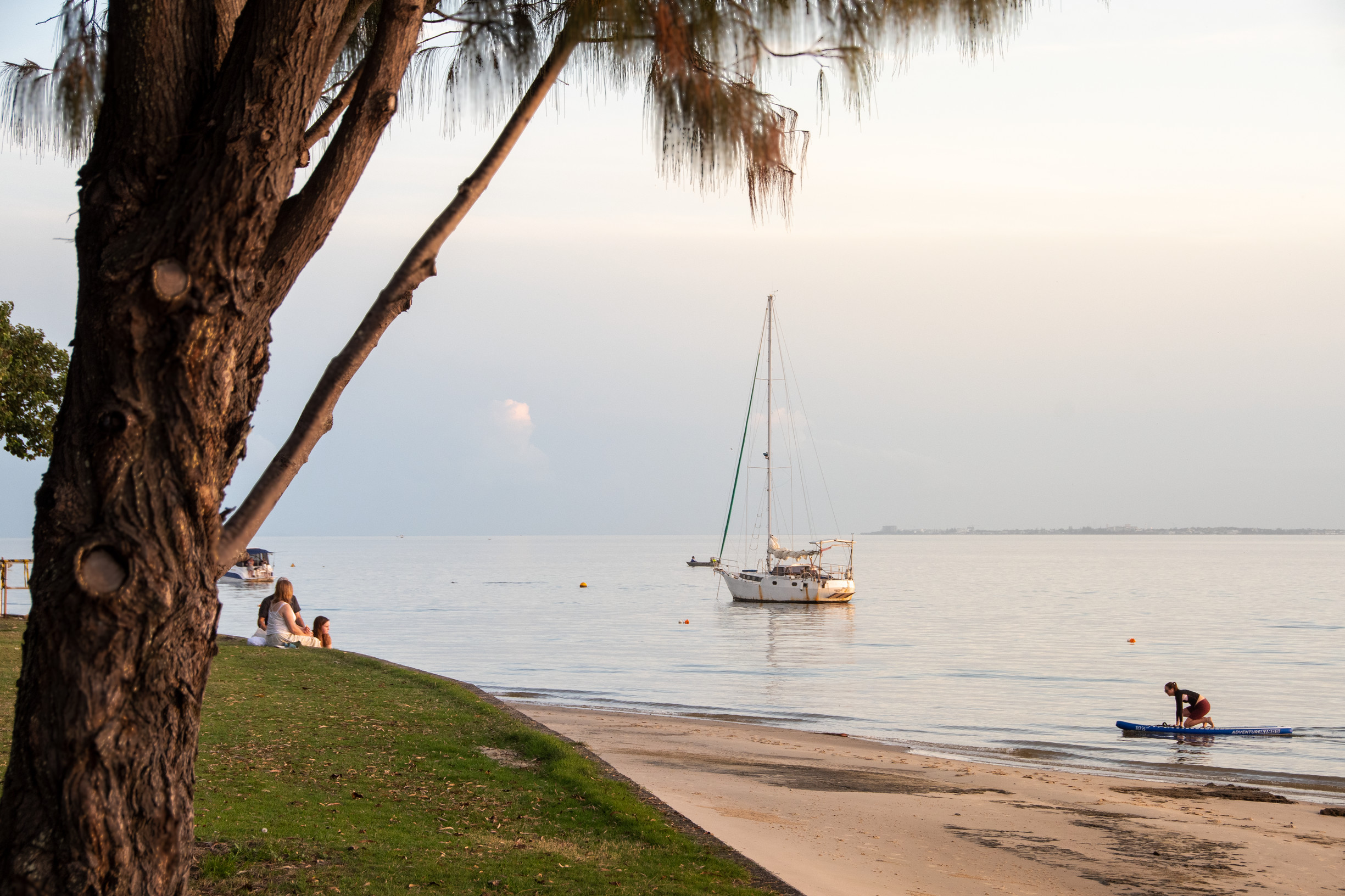 People admiring boat in water at Bongaree Foreshore on Bribie Island People admiring boat in water at Bongaree Foreshore on Bribie Island