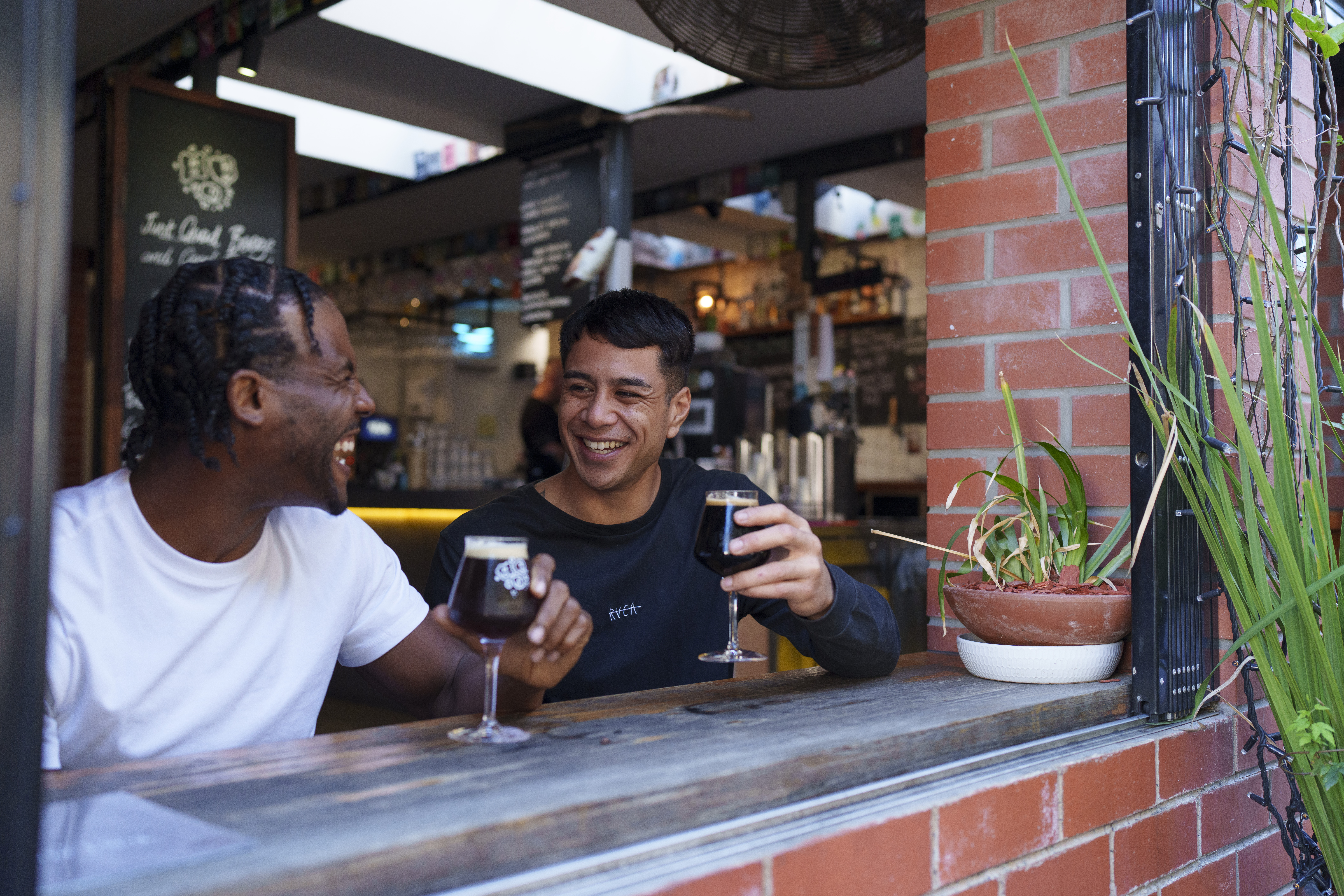 Two friends have a drink at a bar in Fish Lane Two friends have a drink at a bar in Fish Lane