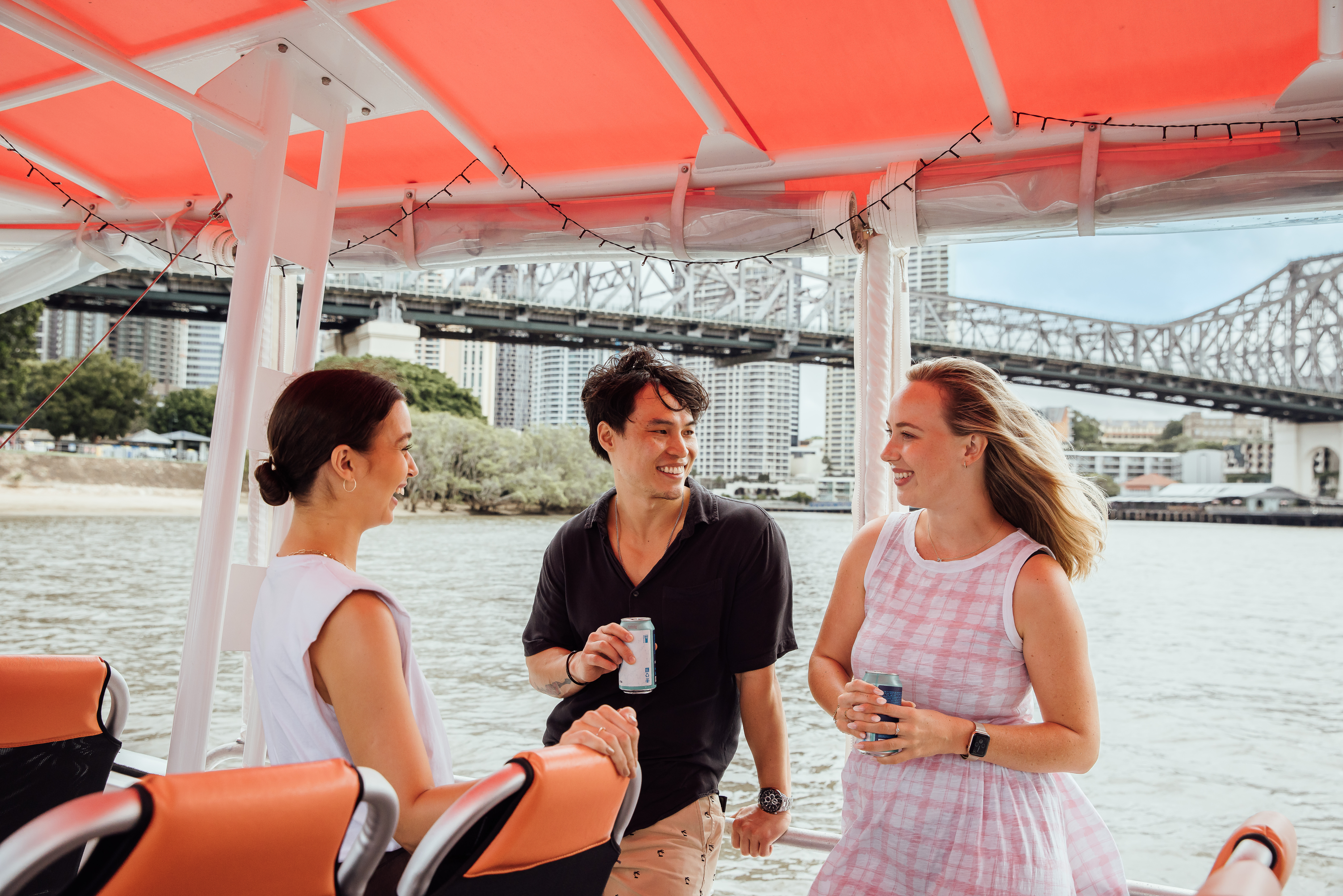 Friends enjoying a boat ride along the Brisbane River