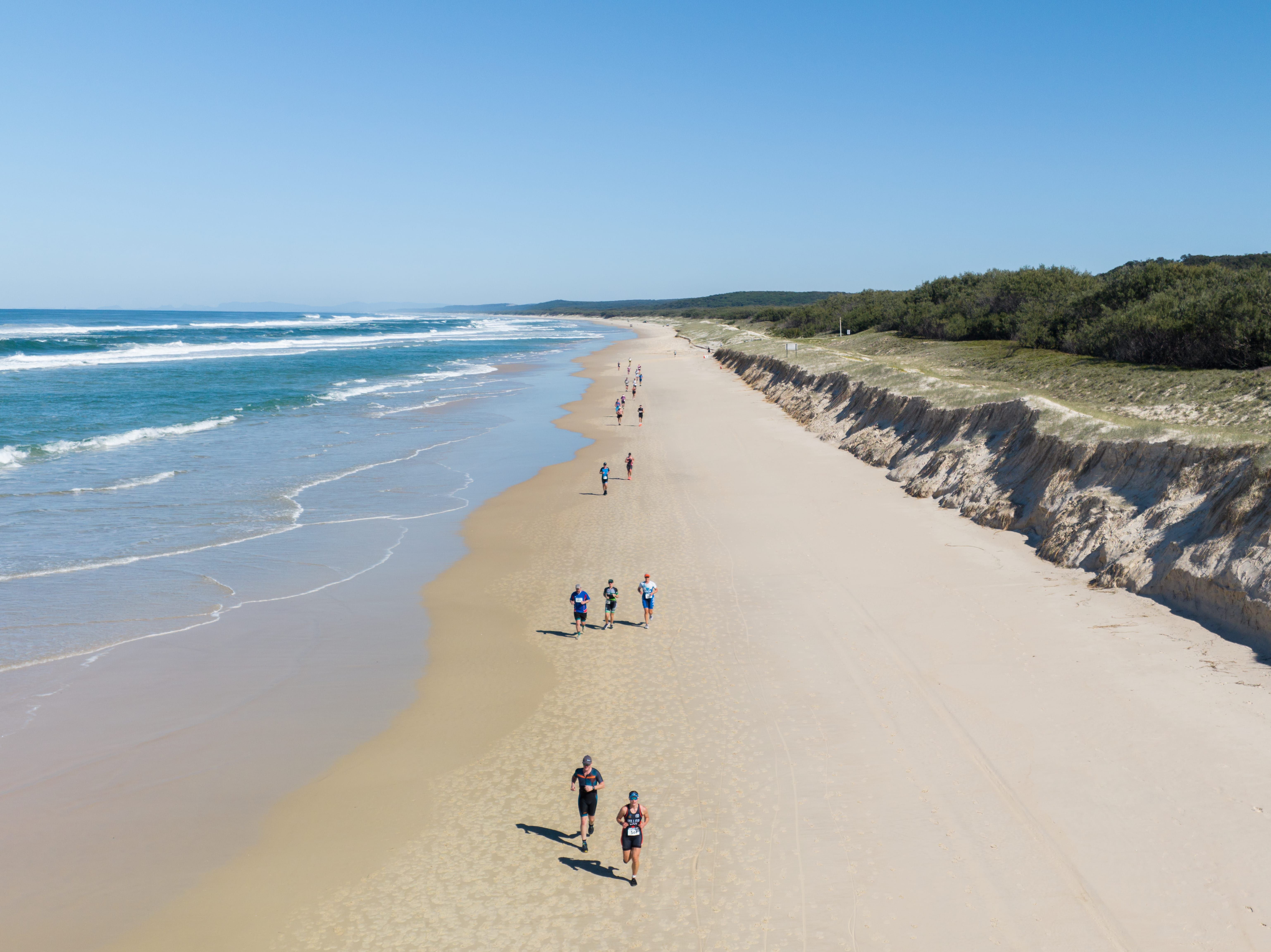 Competitors racing along the beach during Straddie Salute Triathlon Festival