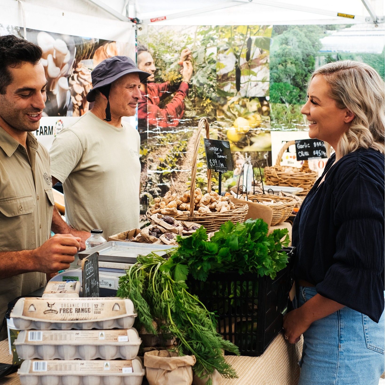 Woman buying fresh produce off a stallowner at Nundah Farmers Markets, Brisbane Woman buying fresh produce off a stallowner at Nundah Farmers Markets, Brisbane