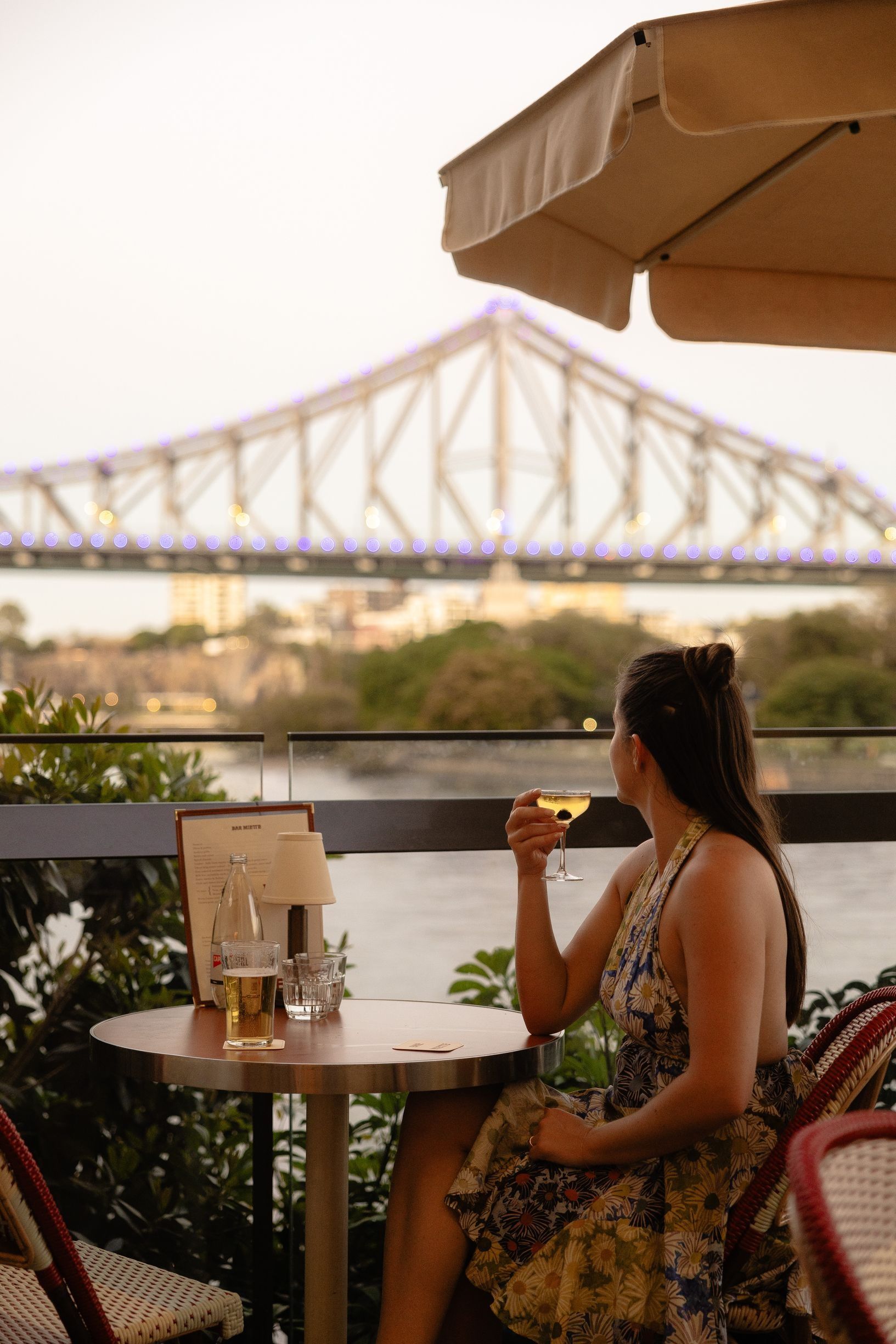 Lady enjoying glass of wine overlooking Story Bridge