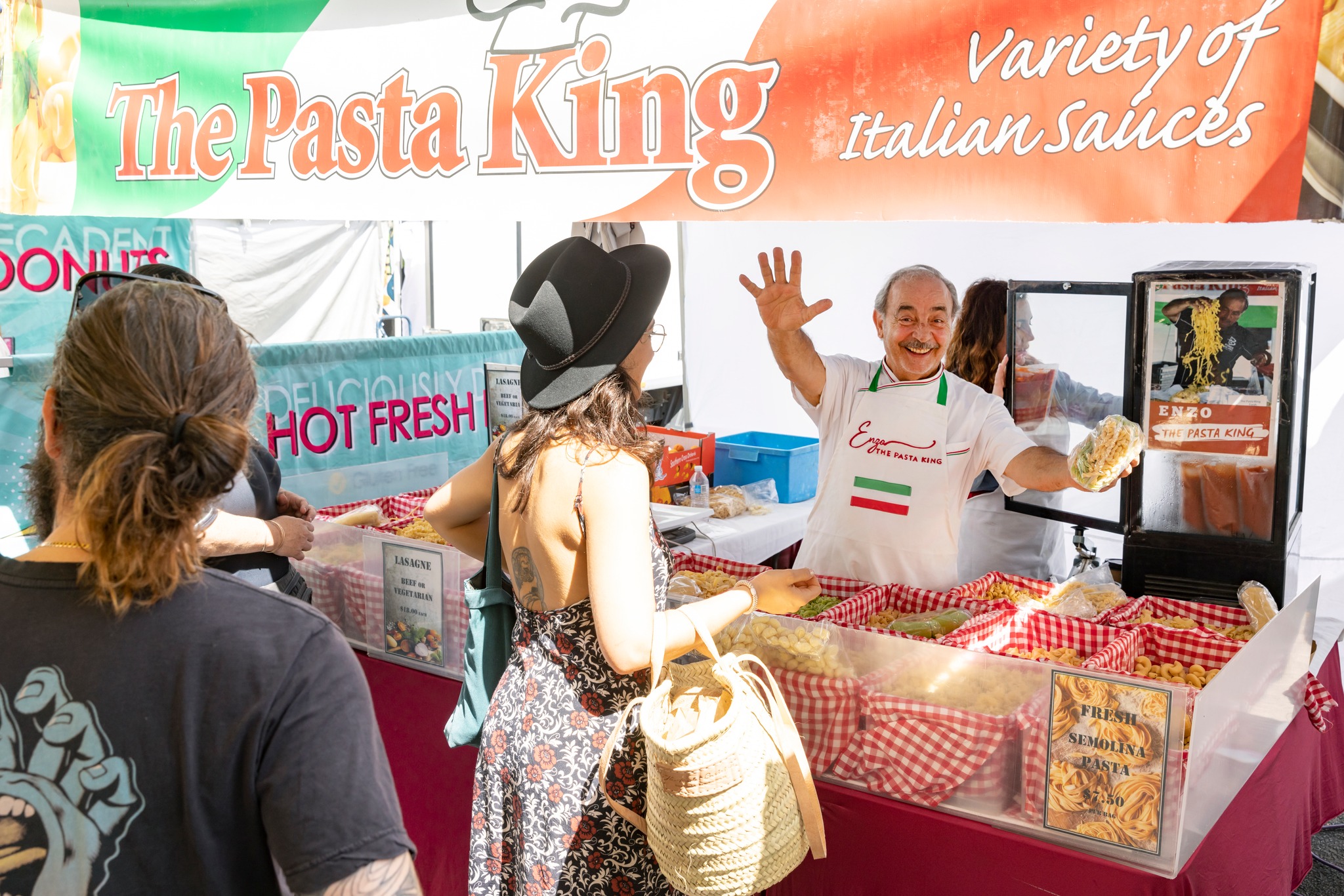 Woman choosing goods from a man selling fresh pasta at Milton Markets Woman choosing goods from a man selling fresh pasta at Milton Markets
