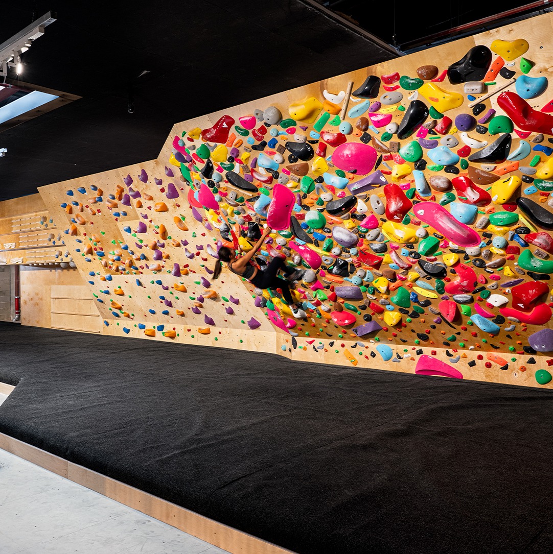Woman climbs a bouldering wall