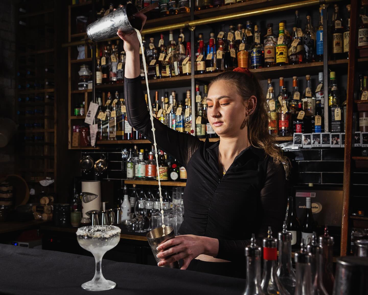 Bartender pours cocktail ingredients into shaker