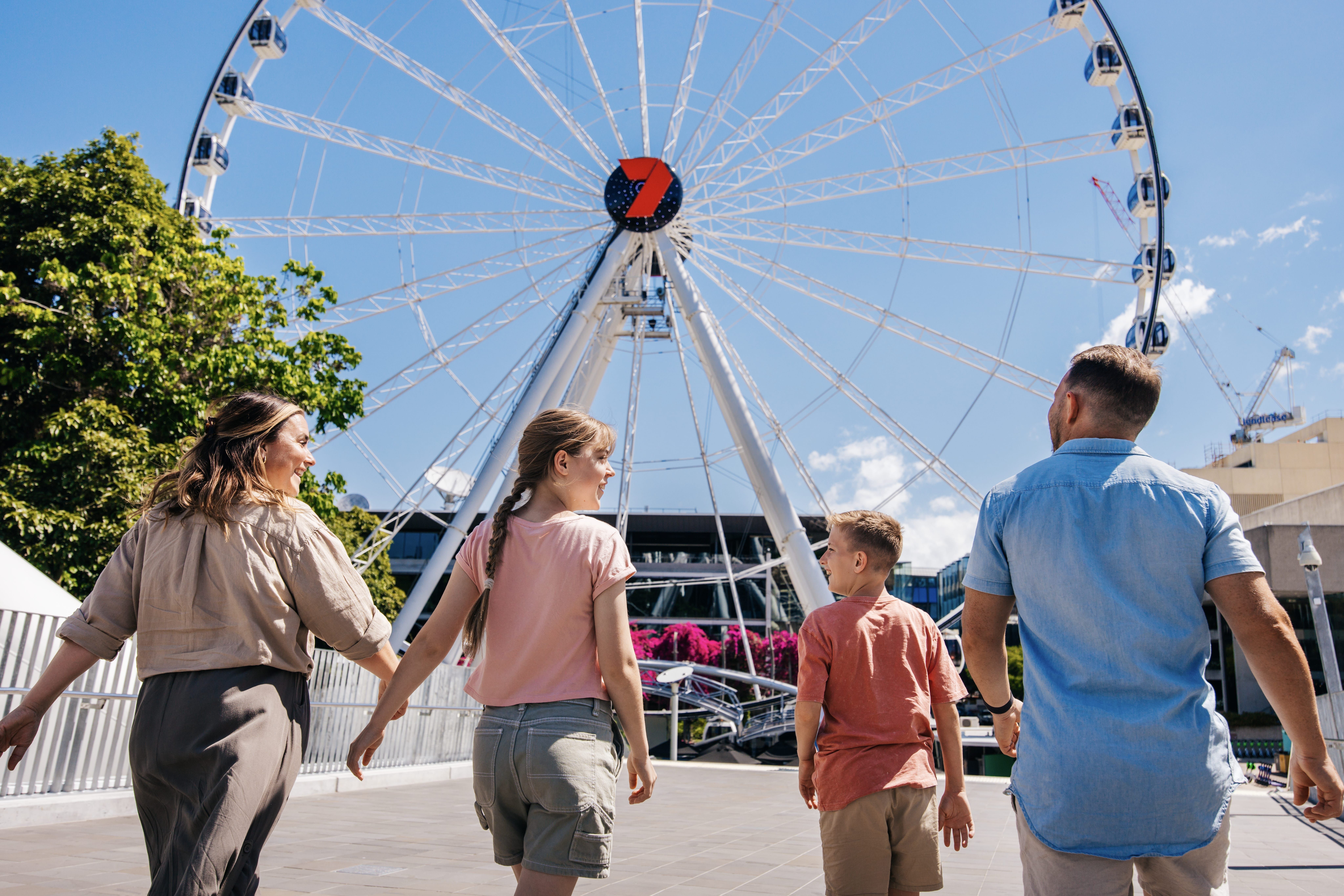 Family walking towards The Wheel of Brisbane