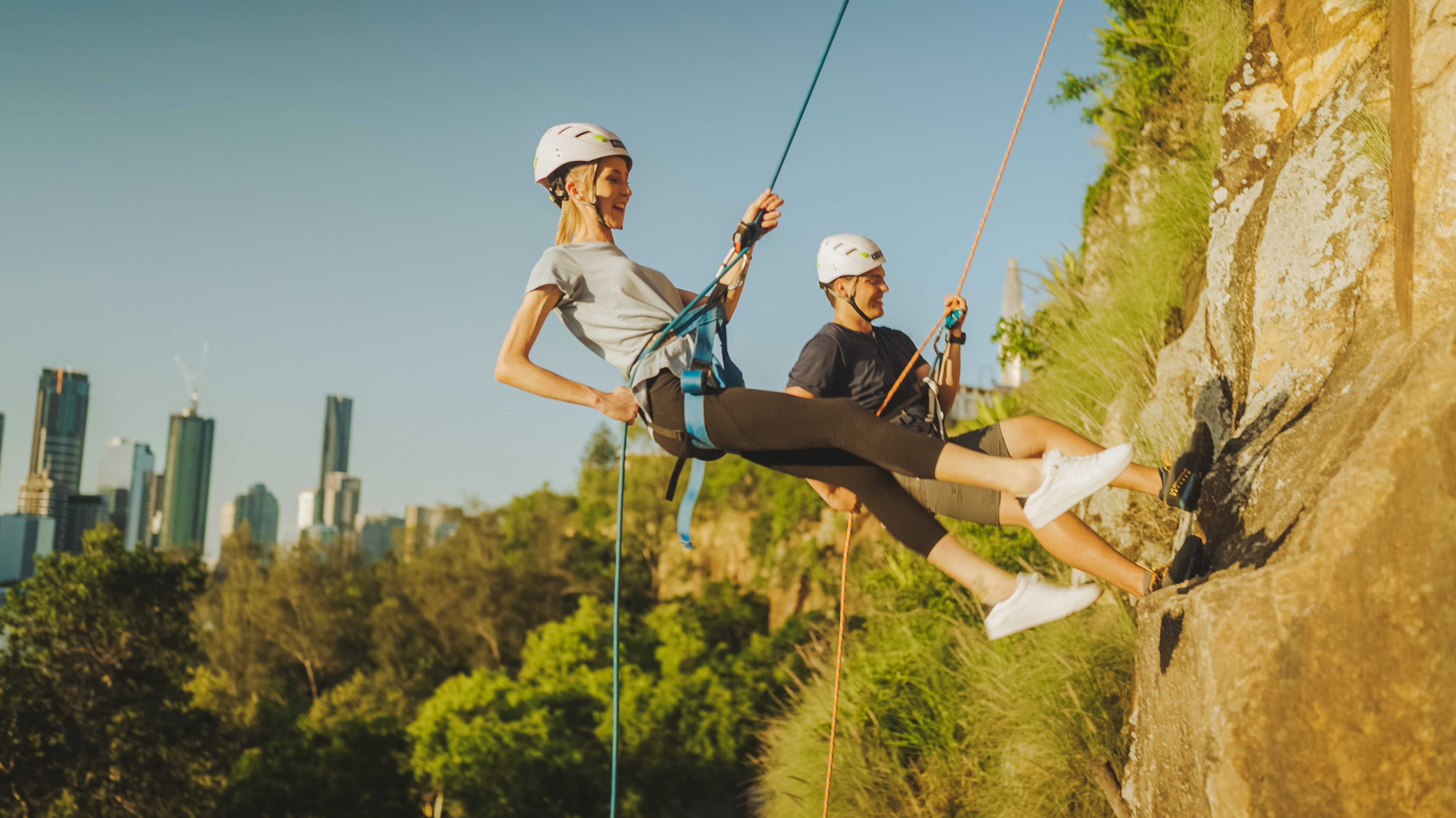 A couple abseiling the Kangaroo Point Cliffs above the Brisbane River A couple abseiling the Kangaroo Point Cliffs above the Brisbane River