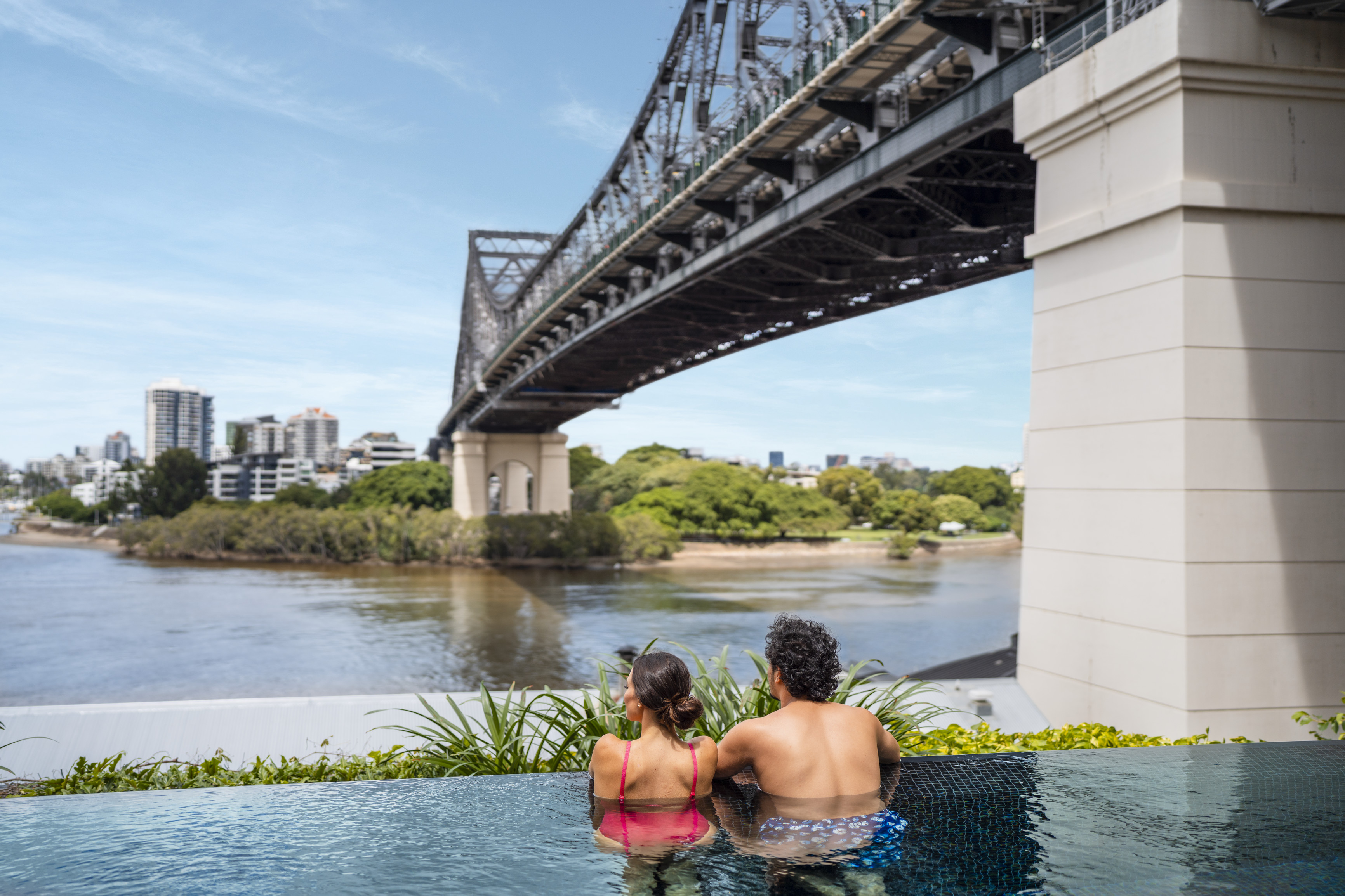 Couple enjpying the views of the Story Bridge, from the Crystalbrook Vincent rooftop pool Couple enjpying the views of the Story Bridge, from the Crystalbrook Vincent rooftop pool