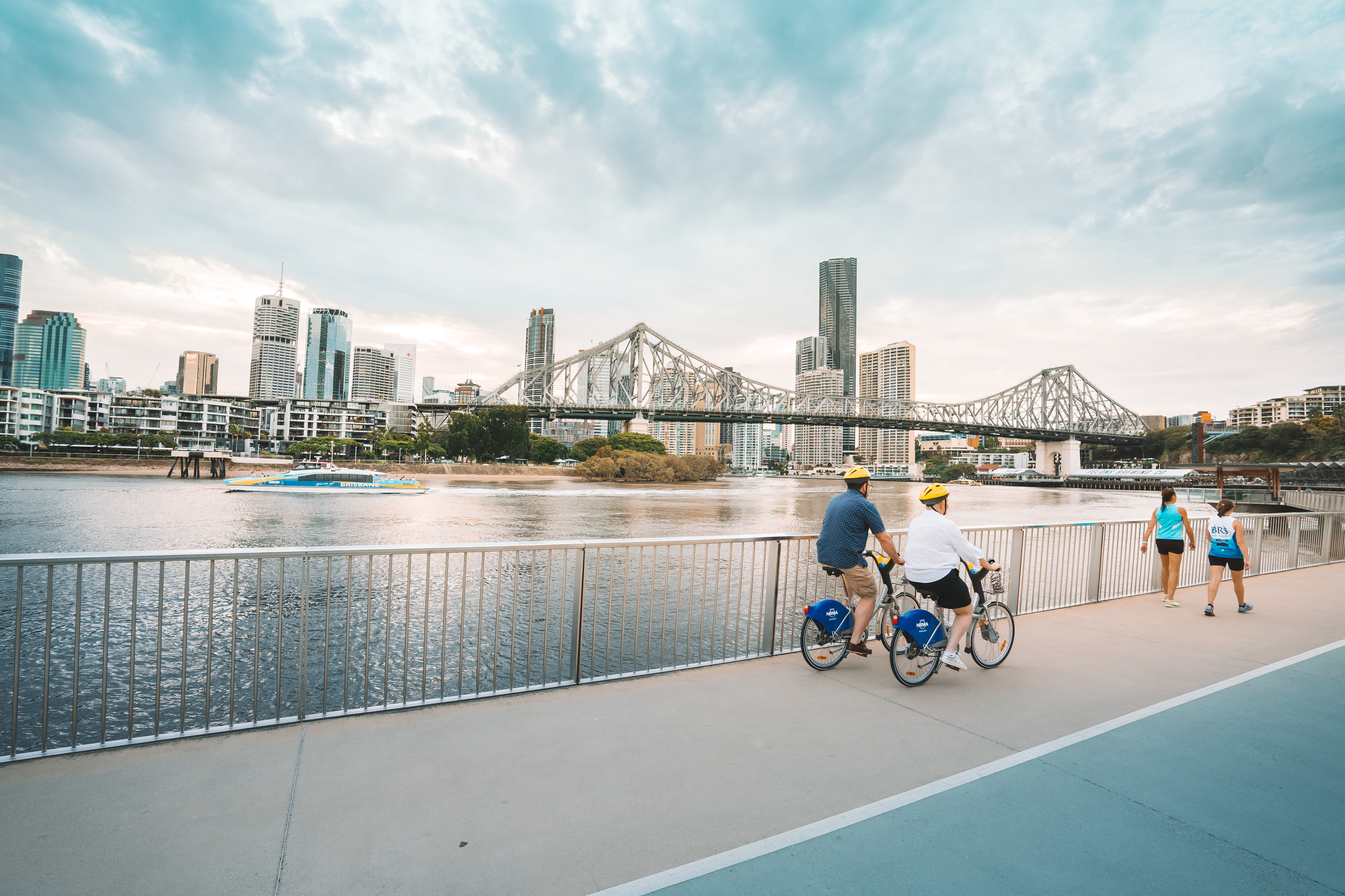 Couple cycling along Brisbane Riverwalk | free things to do Brisbane Couple cycling along Brisbane Riverwalk | free things to do Brisbane