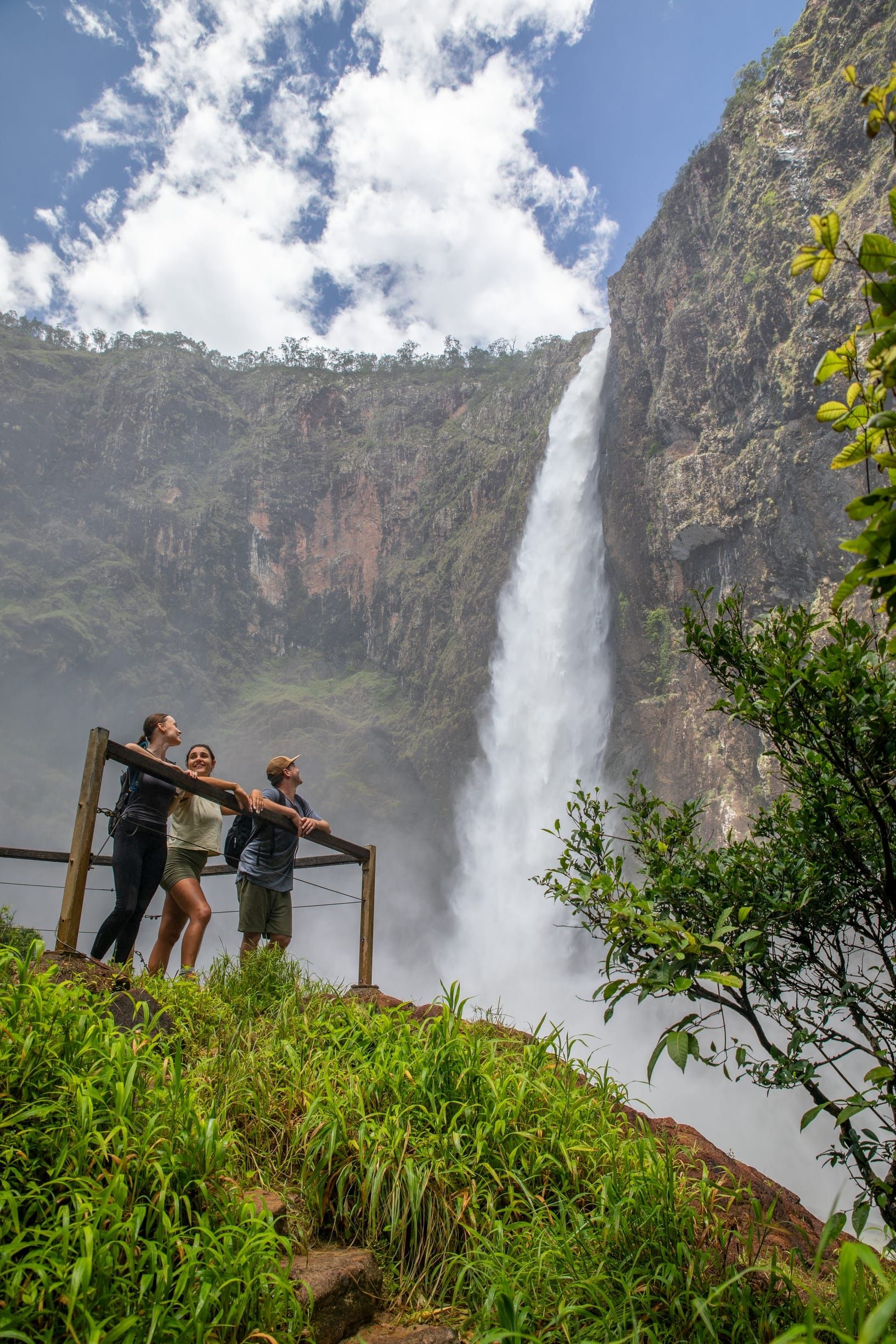 Group enjoying views of a tall waterfall plummeting to the rainforest floor