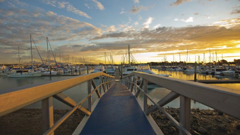 Walkway leading down to a marina with boats in Gladstone Walkway leading down to a marina with boats in Gladstone