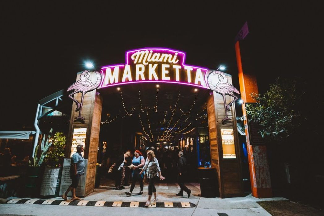 Group of people walking into Miami Marketta at night