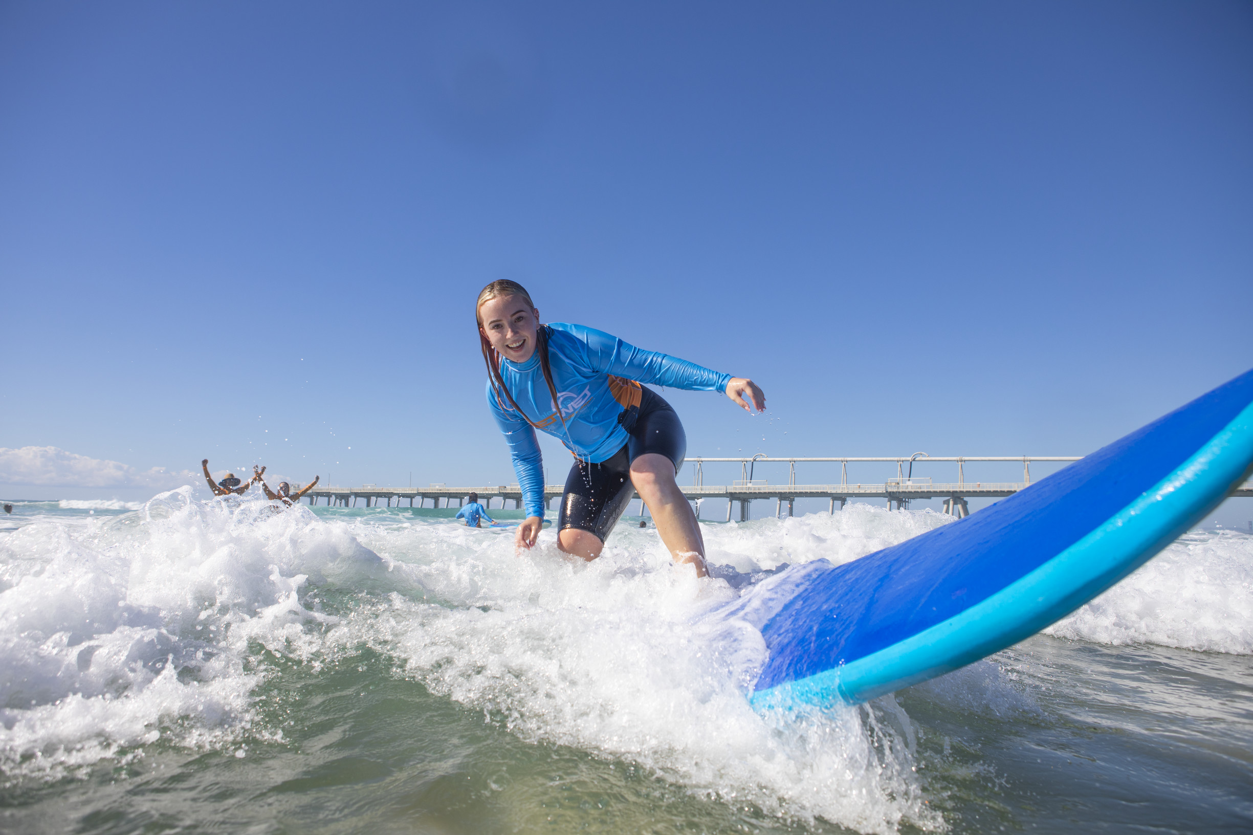 Teenage girl surfs a wave at The Spit on the Gold Coast with Get Wet Surf School