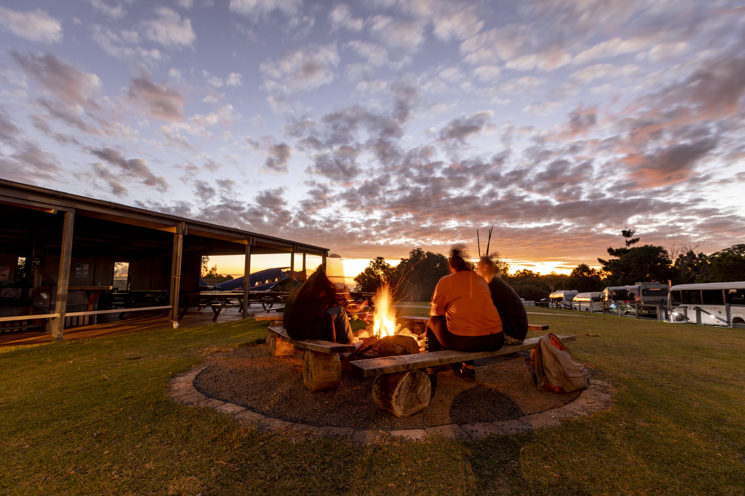 Couple sitting around a camp fire as the sun sets at O'Reilly's Rainforest Retreat, Lamington National Park Couple sitting around a camp fire as the sun sets at O'Reilly's Rainforest Retreat, Lamington National Park