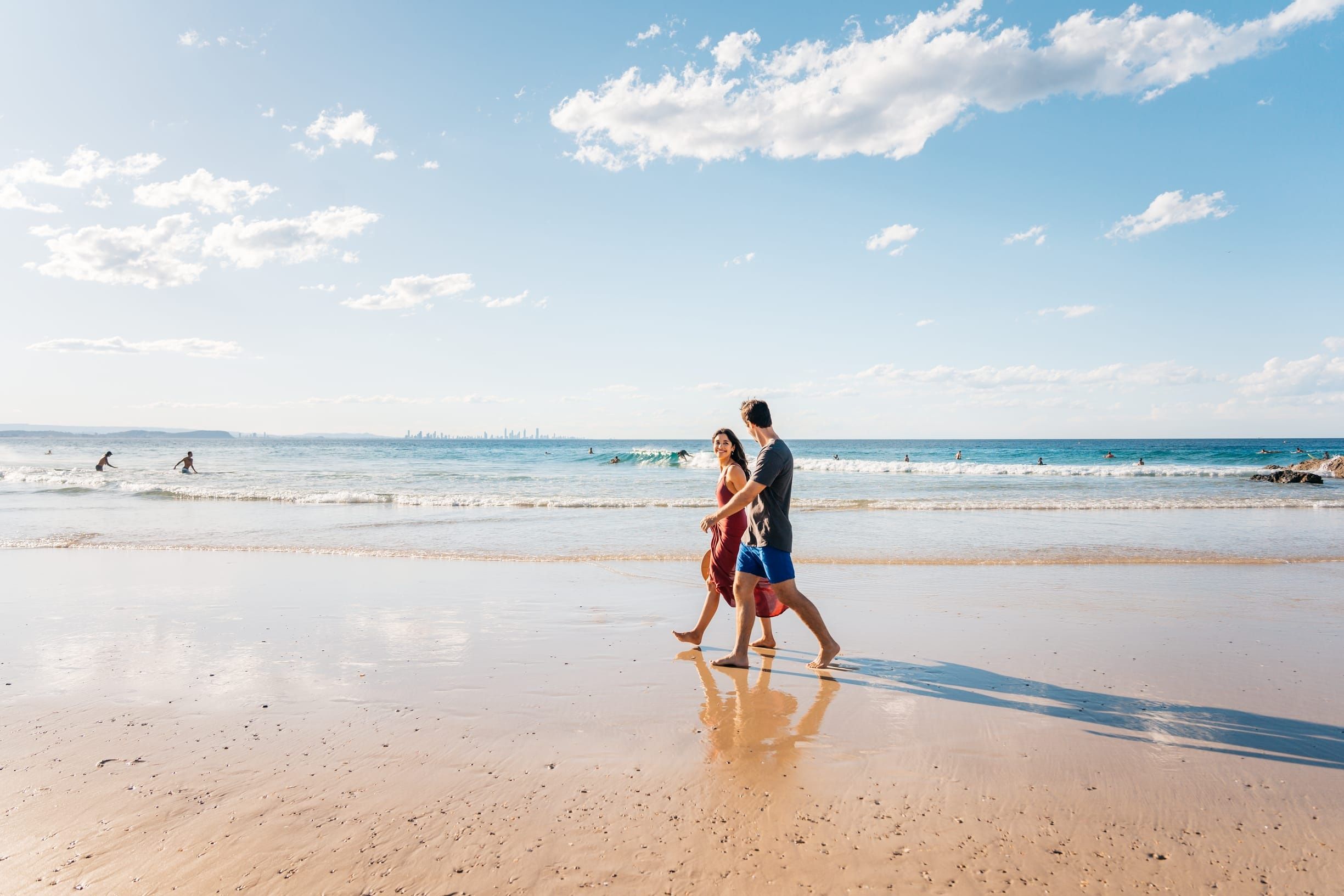 Couple walking along Rainbow Bay Beach