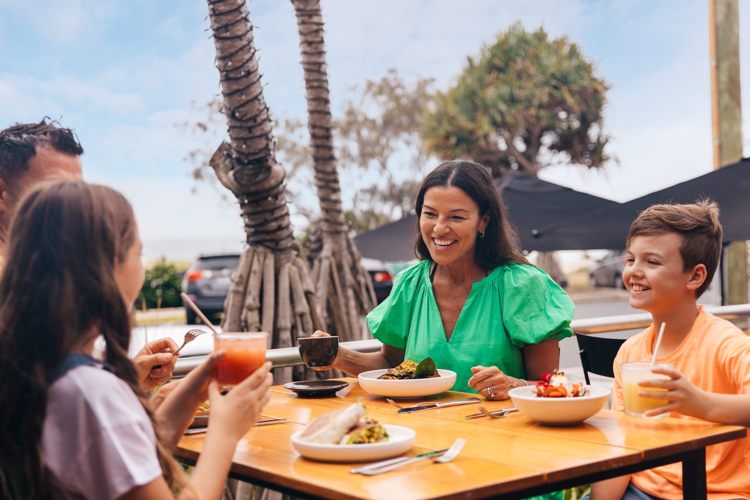 Family enjoying breakfast across the road from the beach at Barefoot Barista Currumbin