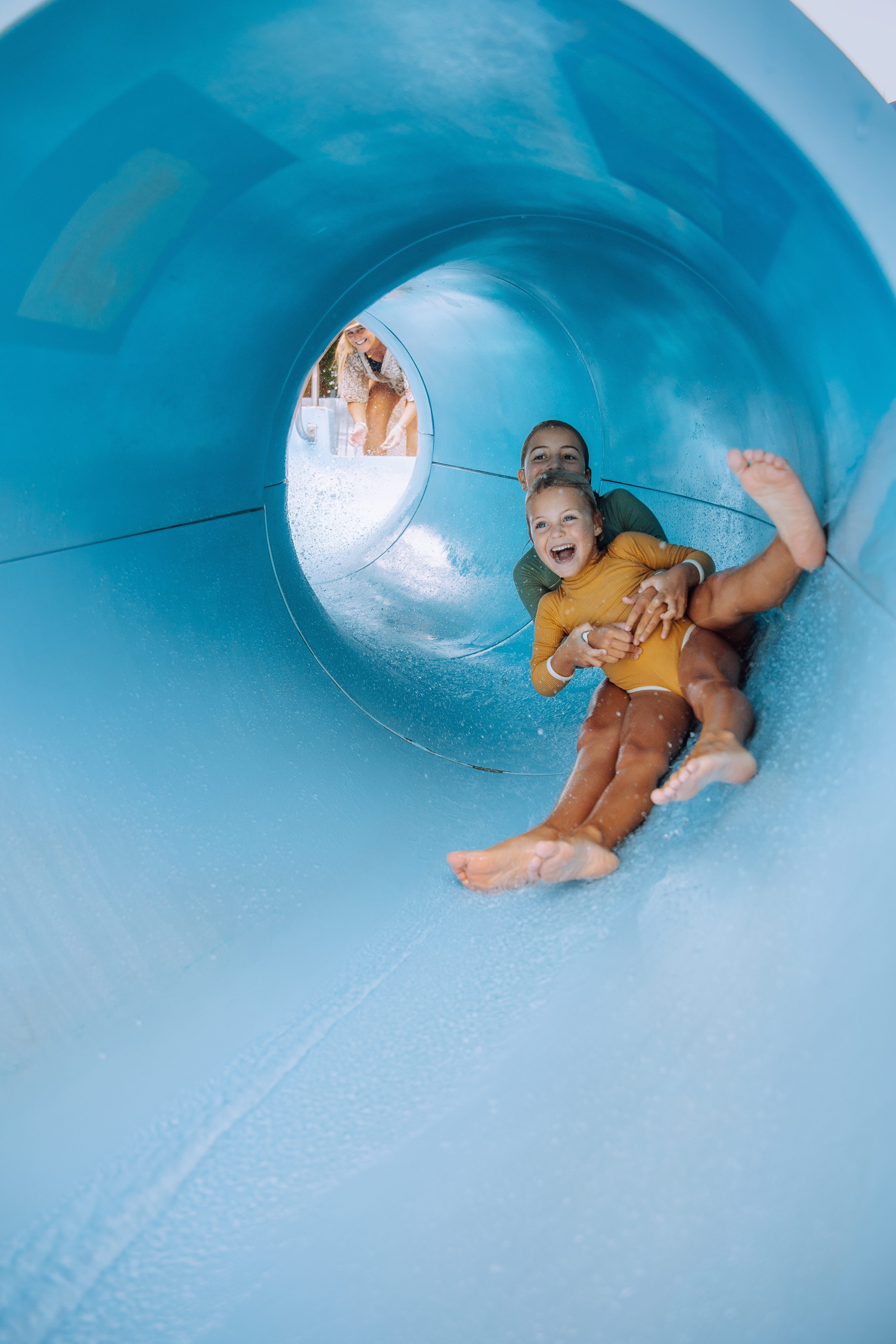 Two young children on a waterslide at Tallebudgera Creek Tourist Park, Gold Coast Two young children on a waterslide at Tallebudgera Creek Tourist Park, Gold Coast