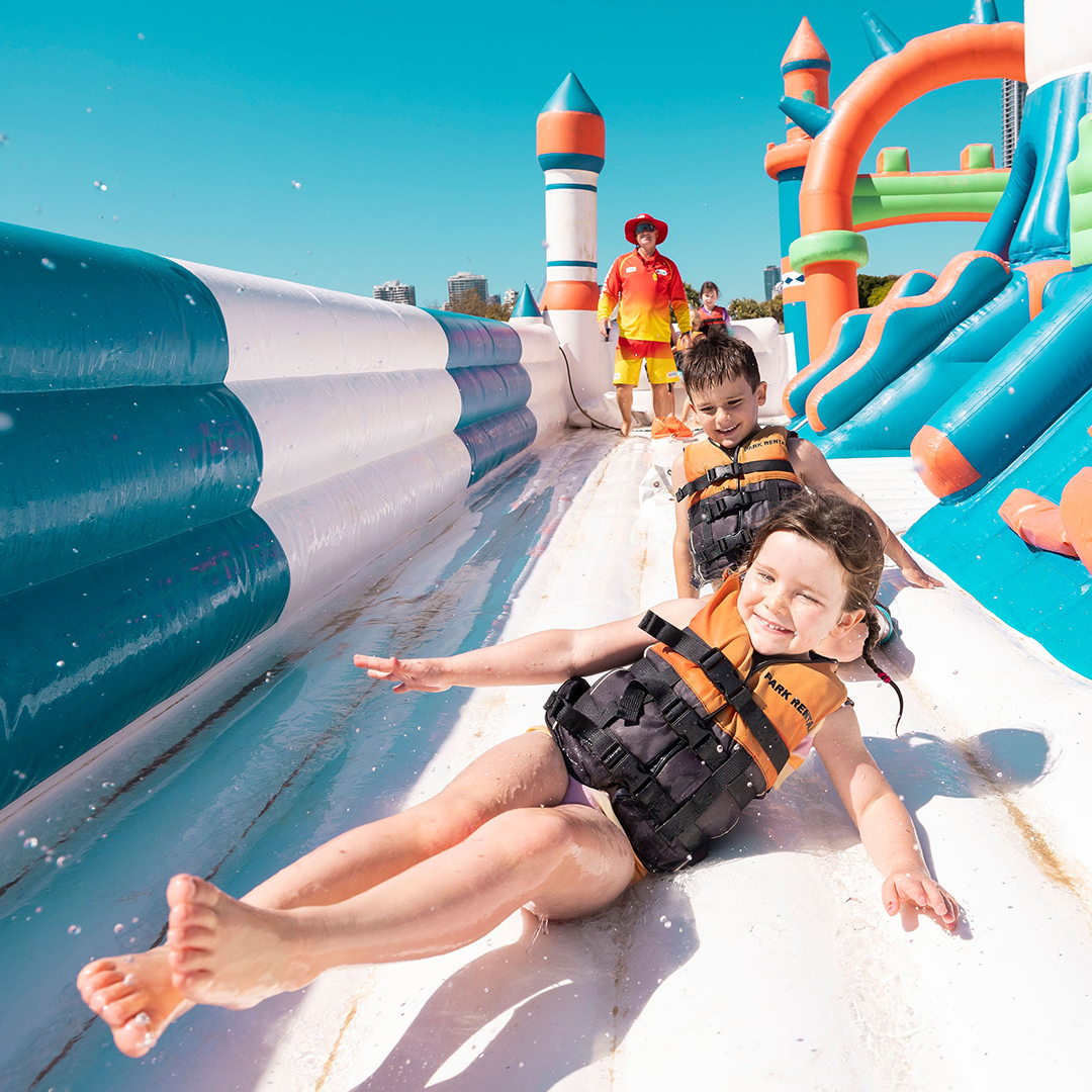 Two kids slide along the inflatable obstacles at GV Aqua Park