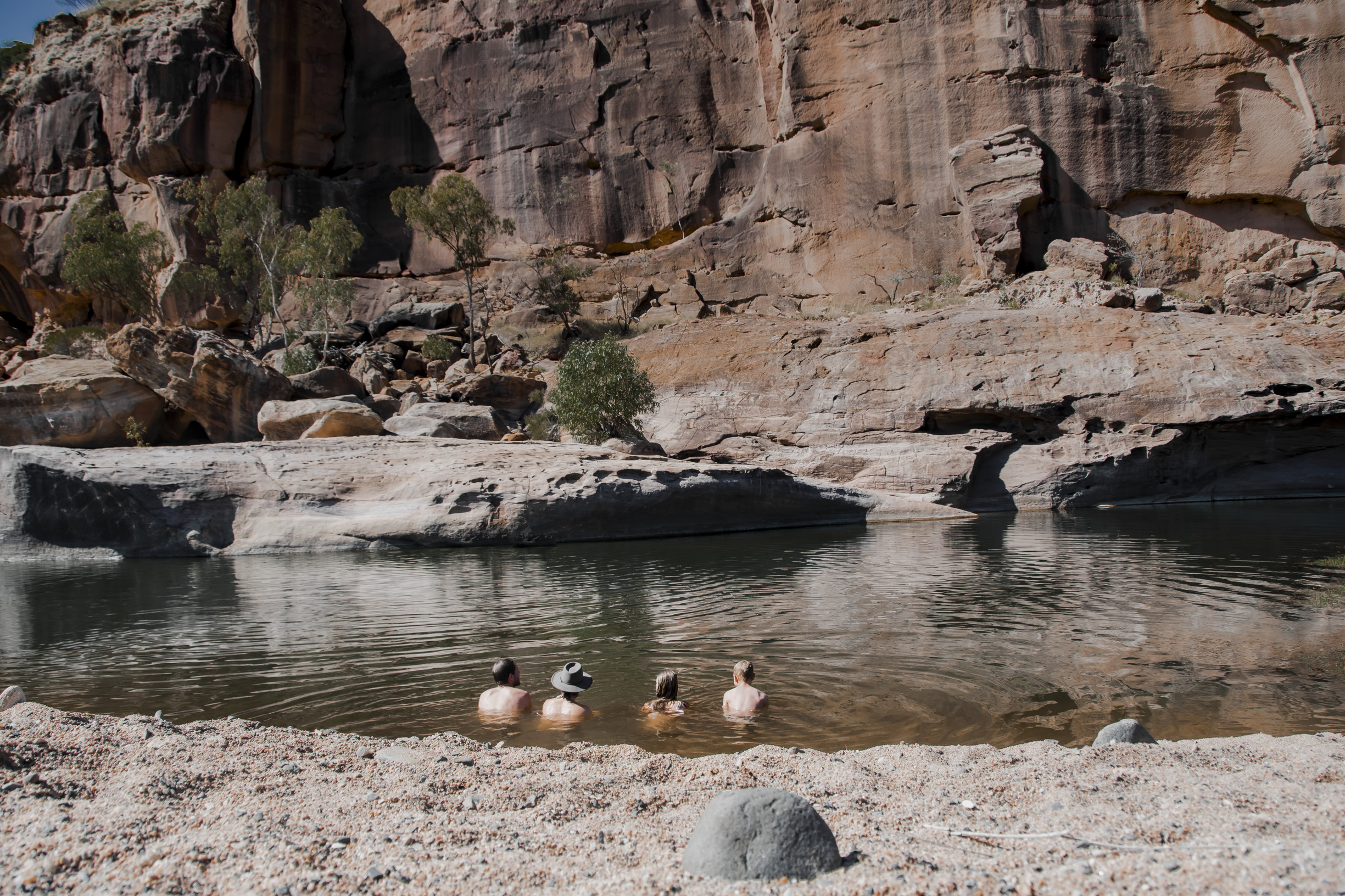Family soaking in the waterhole at Pyramid Camping Area, Porcupine Gorge National Park