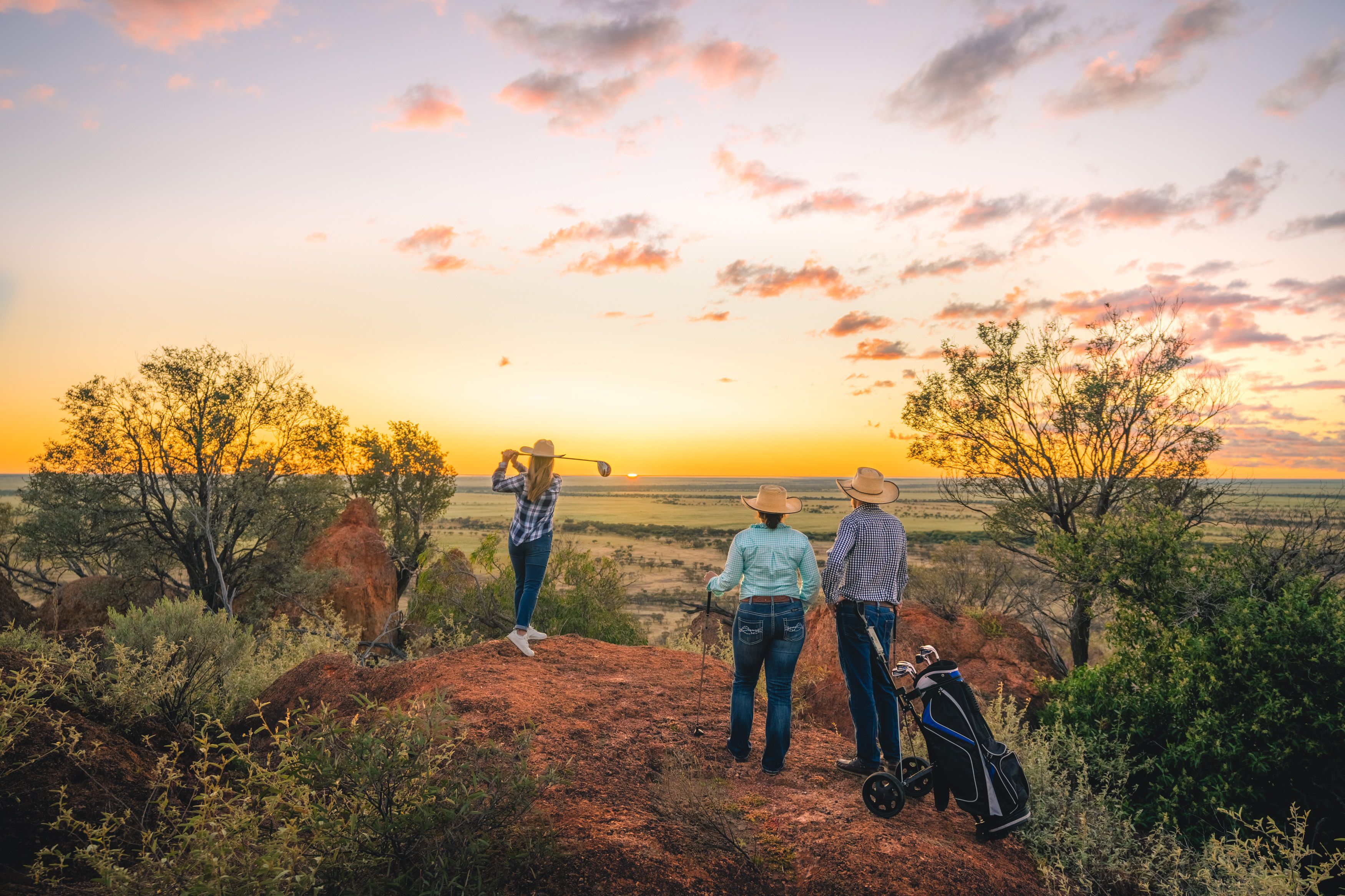 Three golf players looking out at the sunset at Outback Queensland Masters