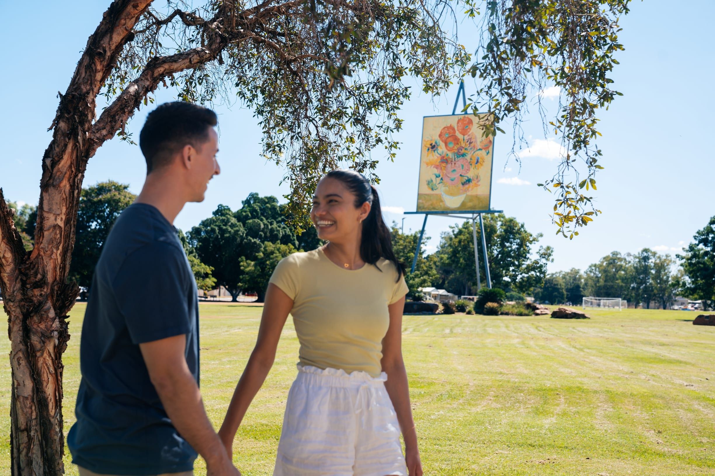 Couple standing near Emerald's The Big Easel - a 25-metre replica of Van Gogh's famous sunflower painting