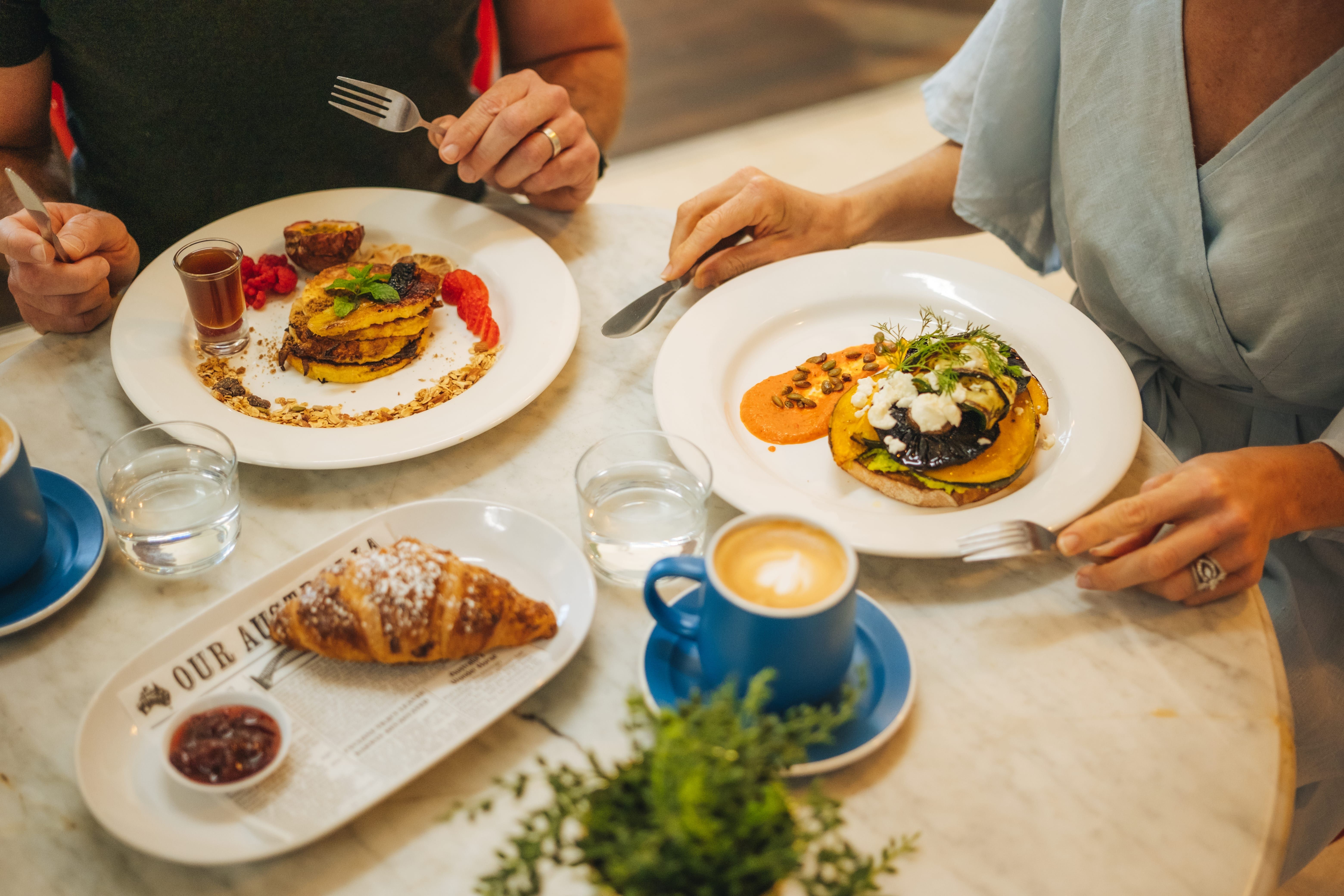 Couple eating breakfast and coffee at a local cafe