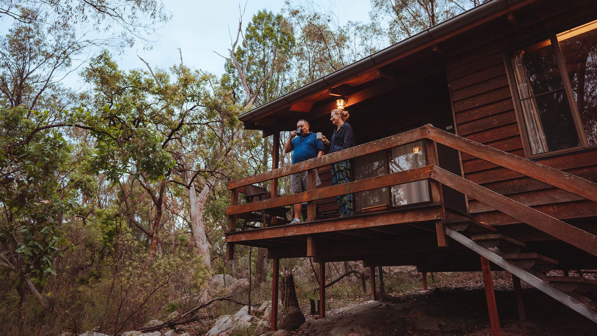 Couple enjoying drink on balcony at Granite Belt Retreat