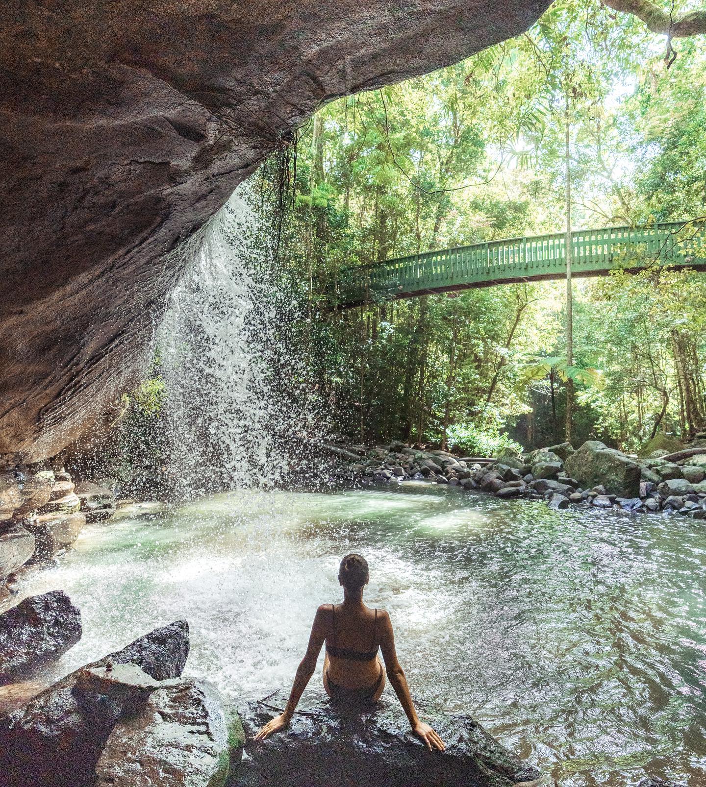 Woman swimming under waterfall at Serenity Falls, near Buderim on the Sunshine Coast Woman swimming under waterfall at Serenity Falls, near Buderim on the Sunshine Coast