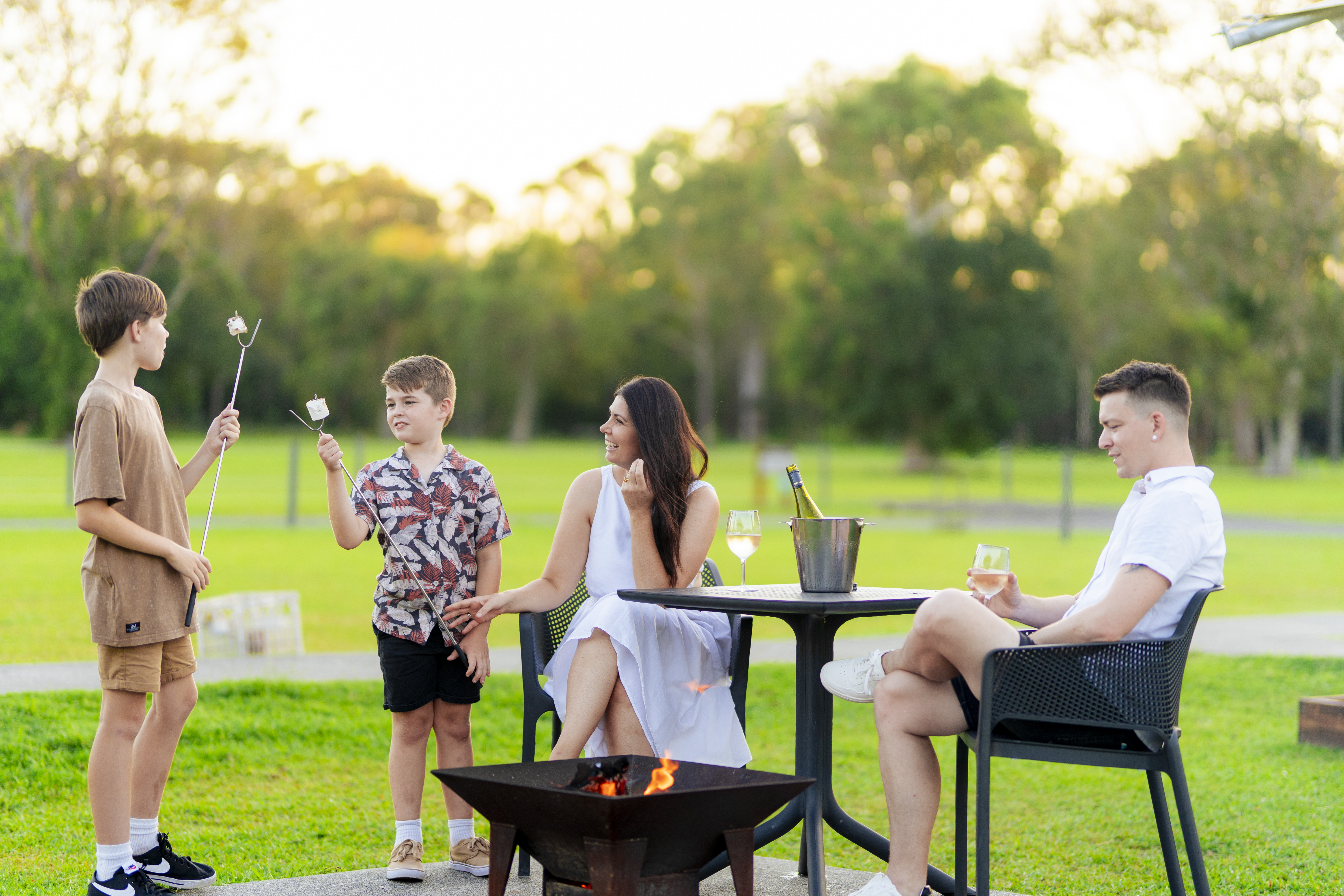 Family having a drink and toasting marshmellows while at Habitat Noosa