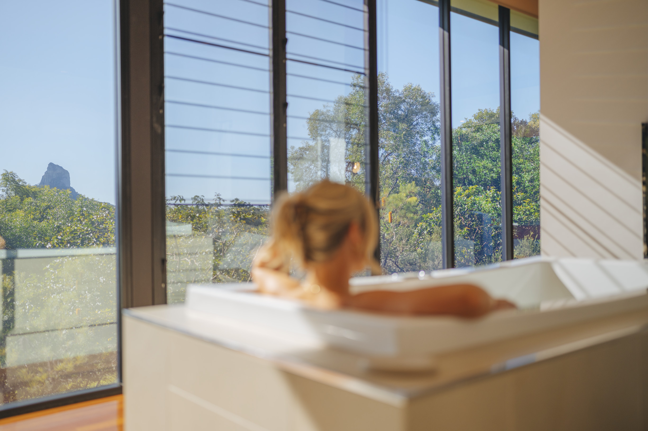 Lady soaking in a bath her villa at Glass on Glasshouse, with views over the Glasshouse Mountains | Bathtubs with amazing views Queensland Lady soaking in a bath her villa at Glass on Glasshouse, with views over the Glasshouse Mountains | Bathtubs with amazing views Queensland