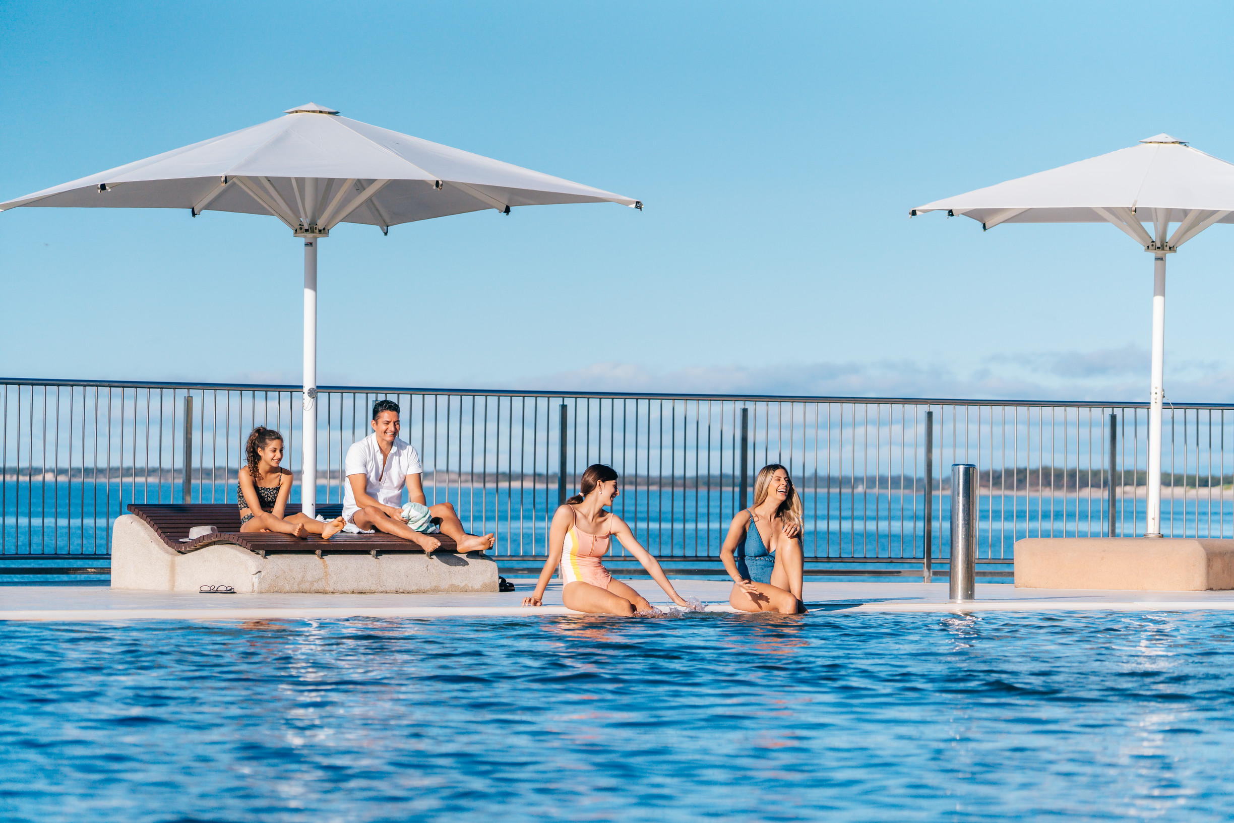 Family relaxing by Kings Beach Beachfront Salt Water Pool, Caloundra
