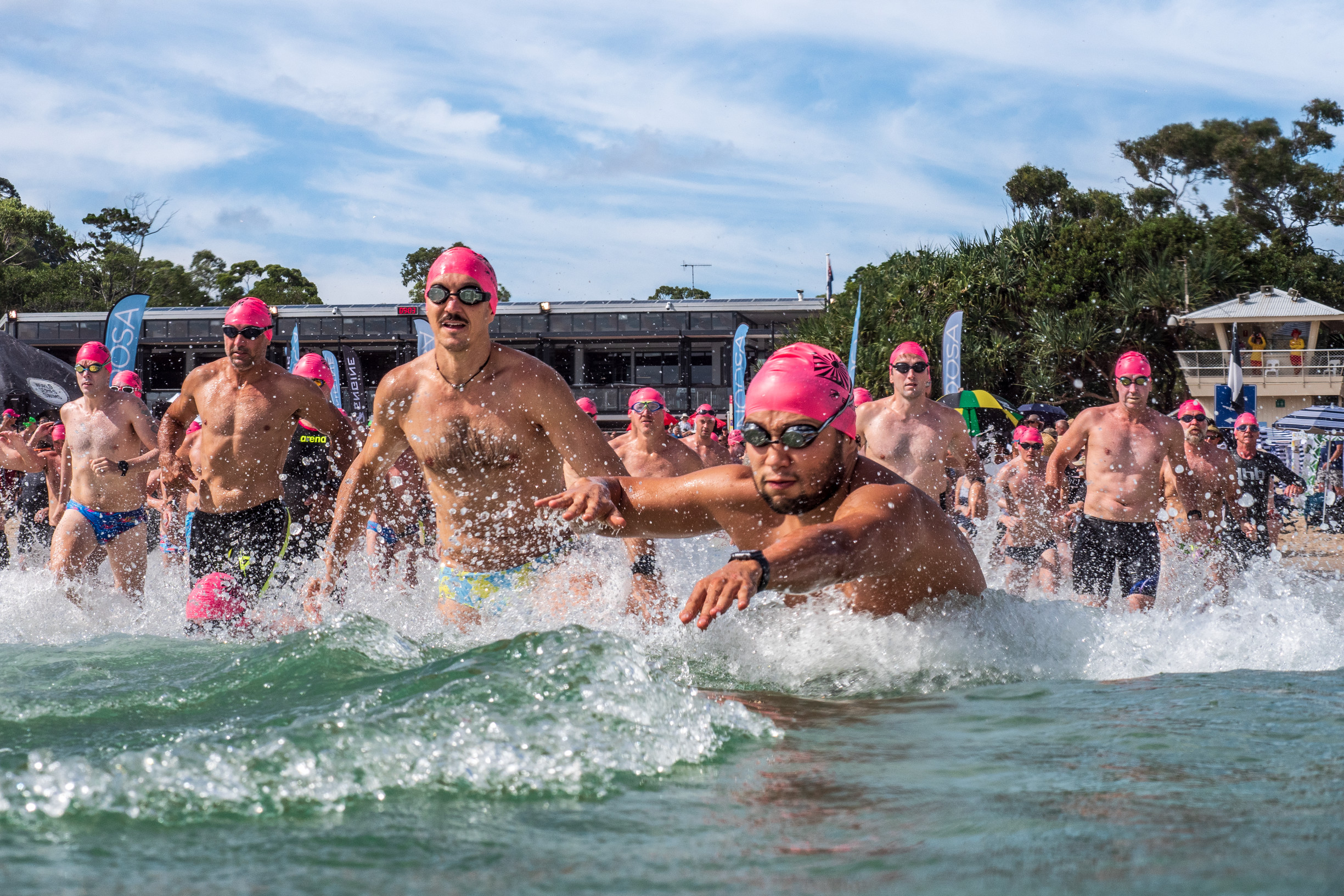 Swimmers running through the water, ready for their ocean swim race