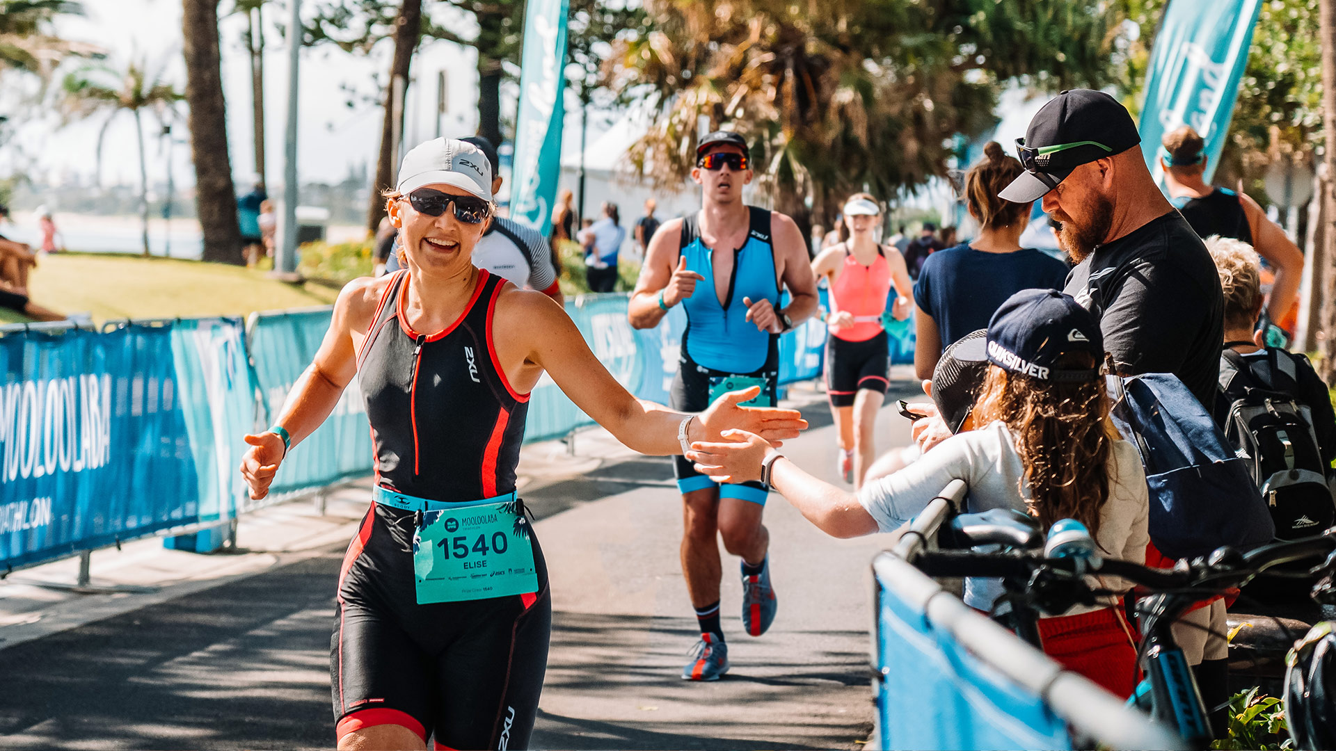 Competitor running through crowd during Mooloolaba Triathlon