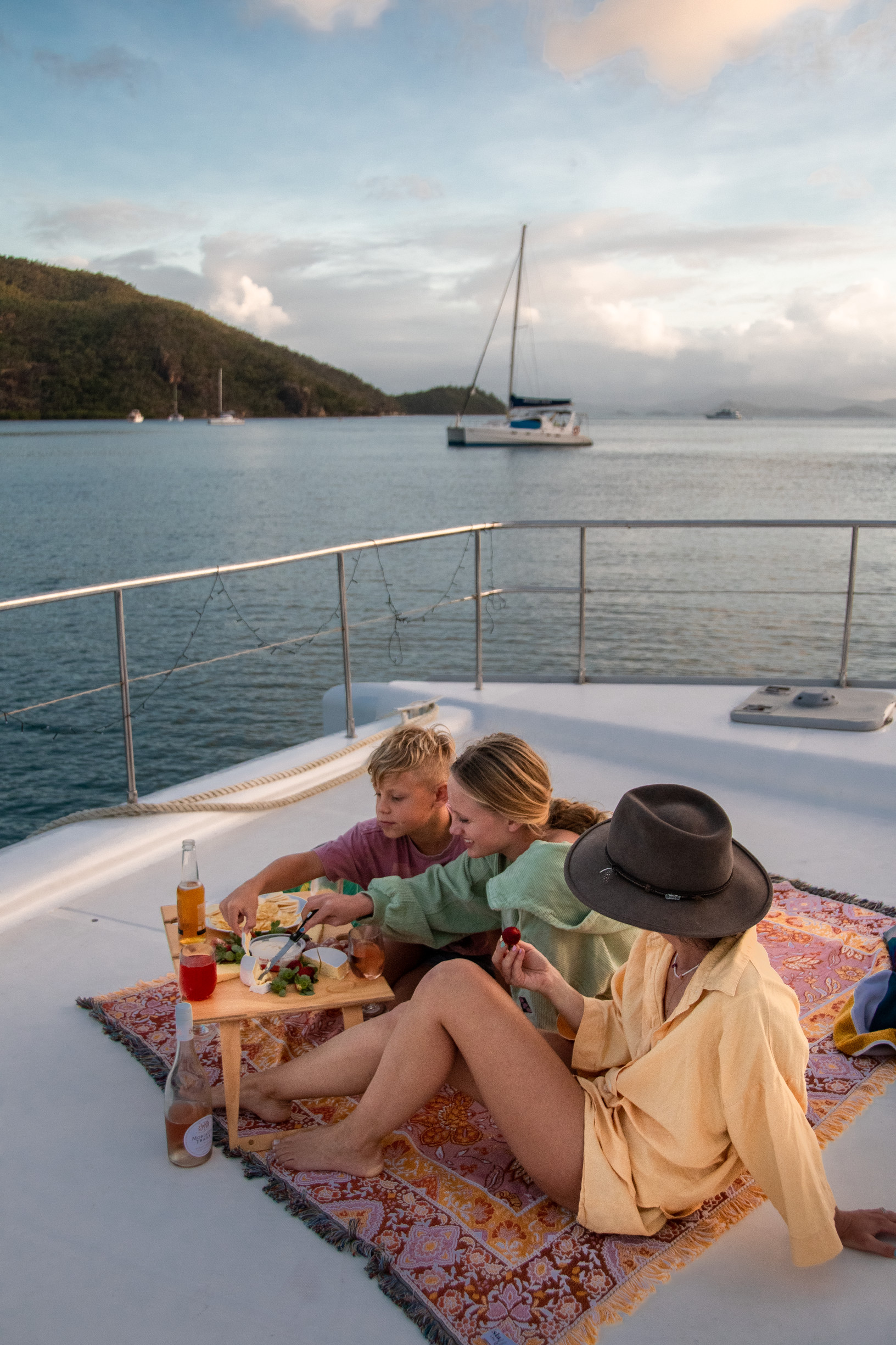 Family enjoying a sundowner on board a bareboat charter | family sailing holiday whitsundays Family enjoying a sundowner on board a bareboat charter | family sailing holiday whitsundays