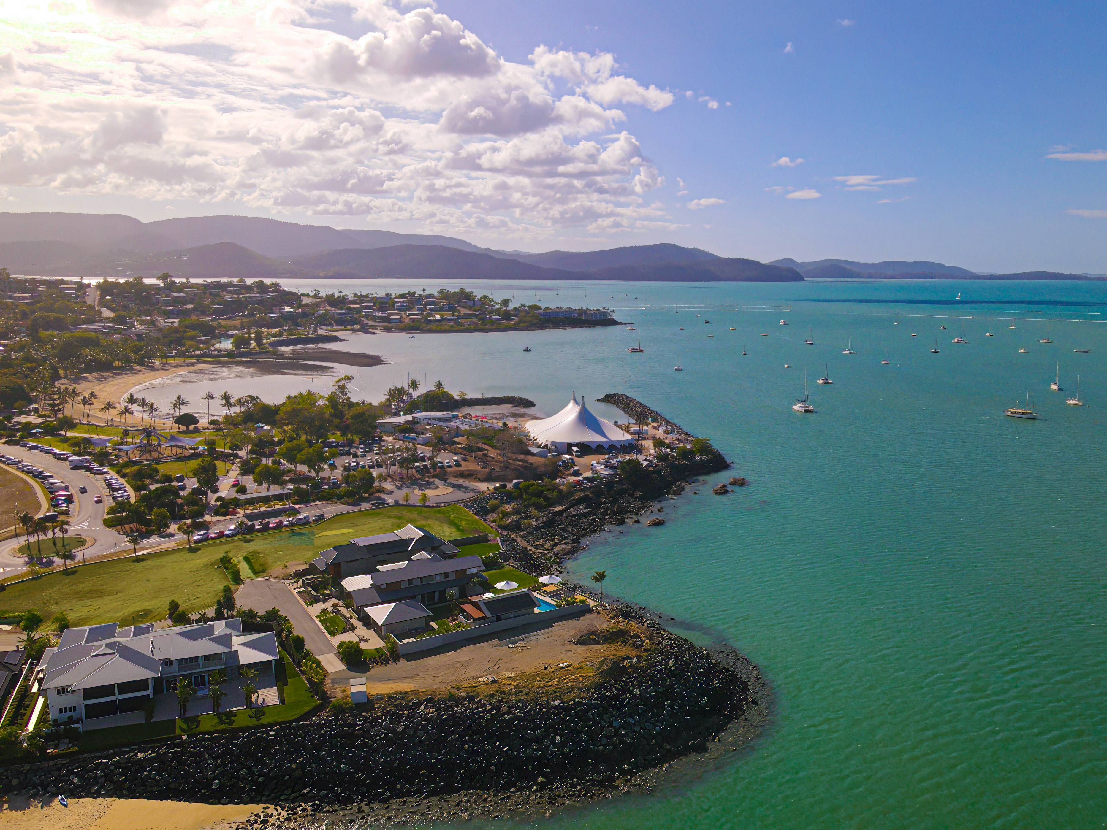 Aerial view of Airlie Beach Festival of Music, with vibrant blue waters and Whitsundays coastline in background