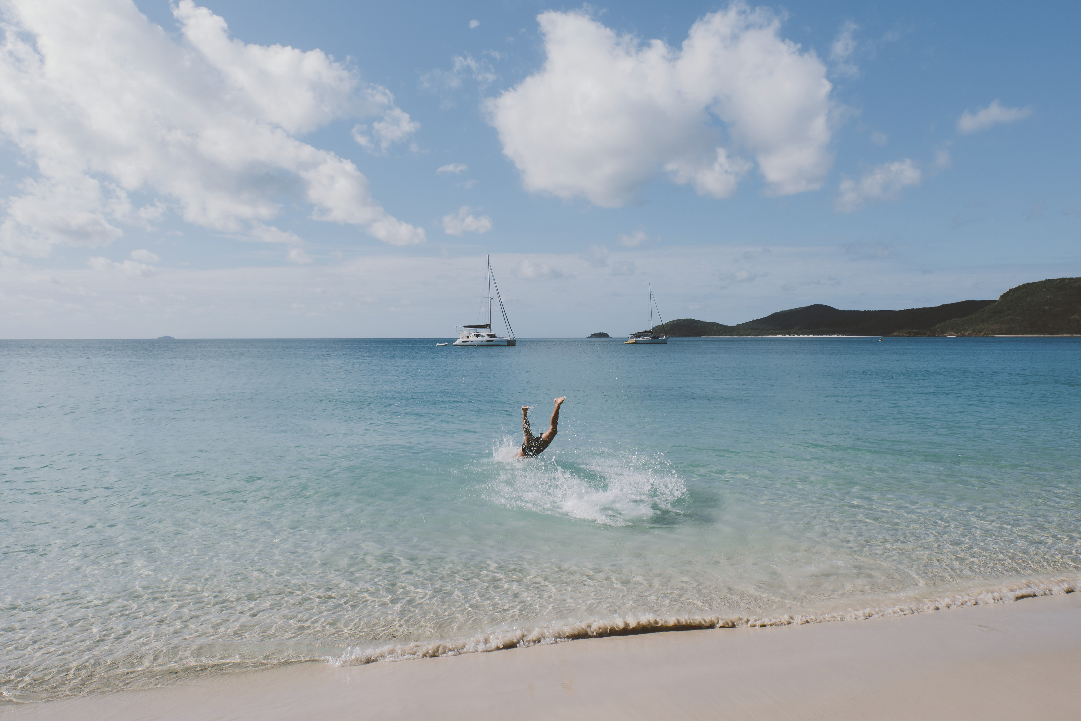A man diving into the water at Whitehaven Beach