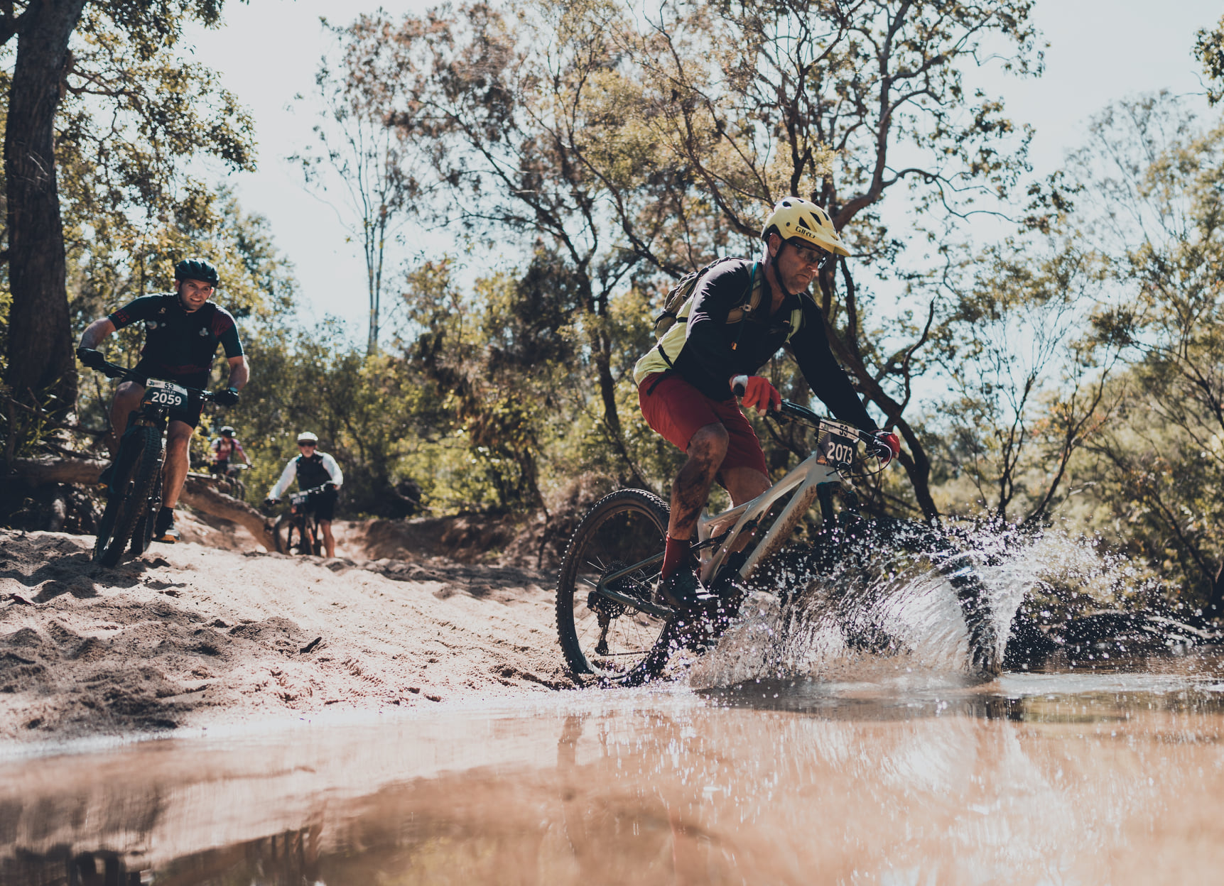 Mountain bikers riding through a river at Paluma Push Mountain bikers riding through a river at Paluma Push