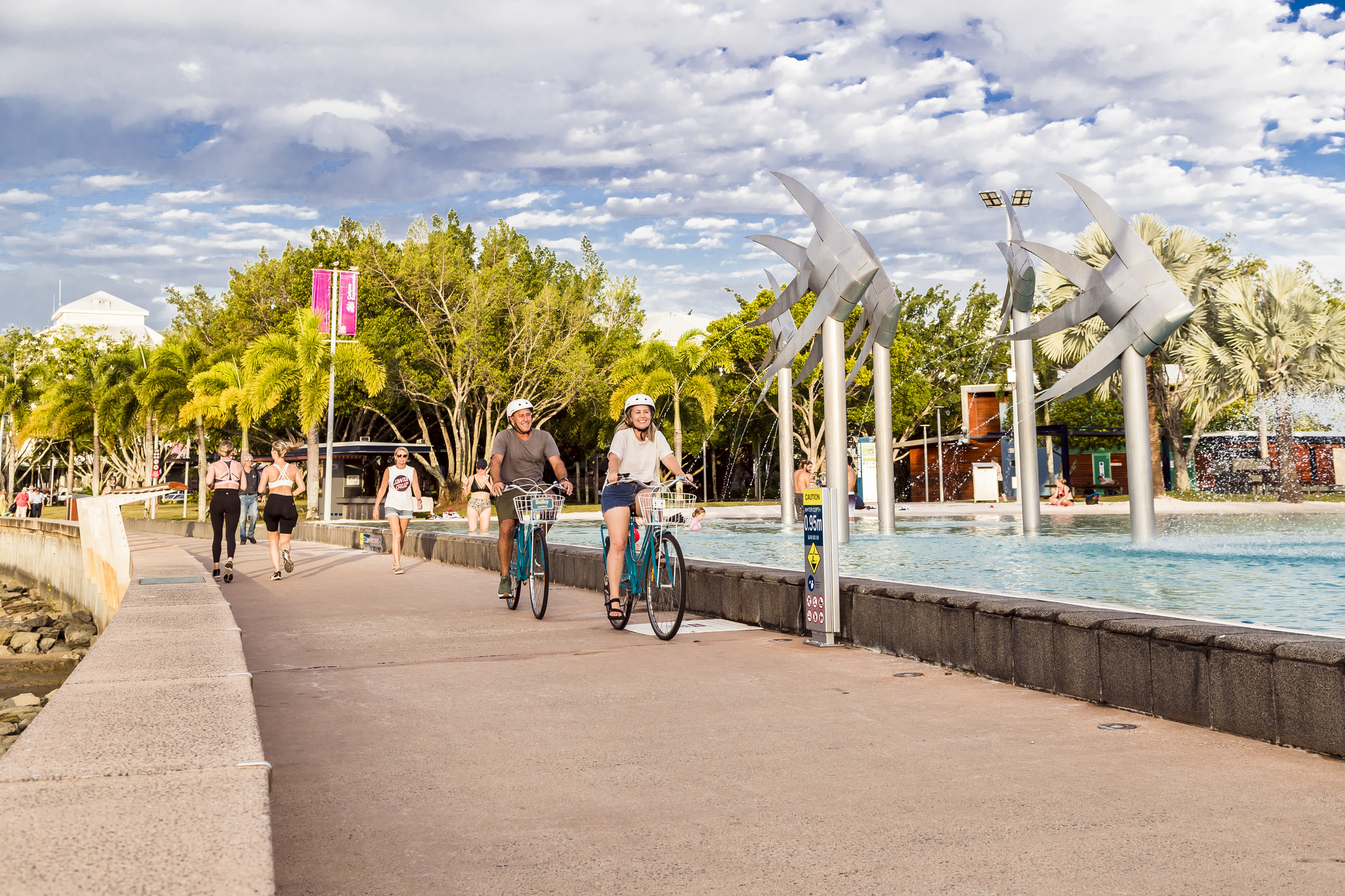 Couple bike riding along the Esplanade in Cairns