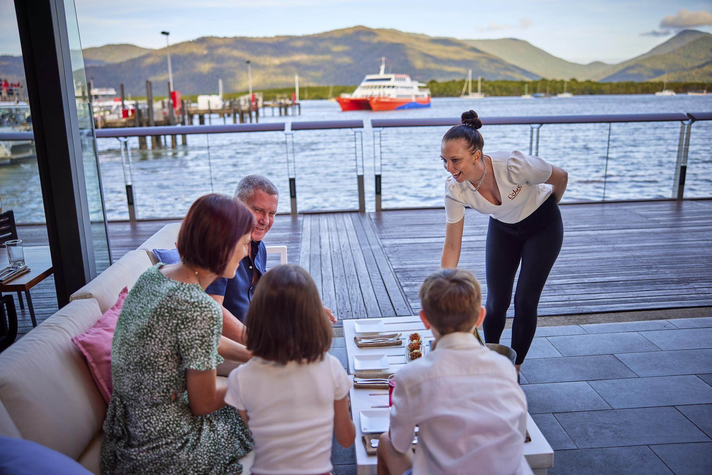 Wait staff dropping off food to a family dining at Ochre Restaurant, Cairns Wait staff dropping off food to a family dining at Ochre Restaurant, Cairns