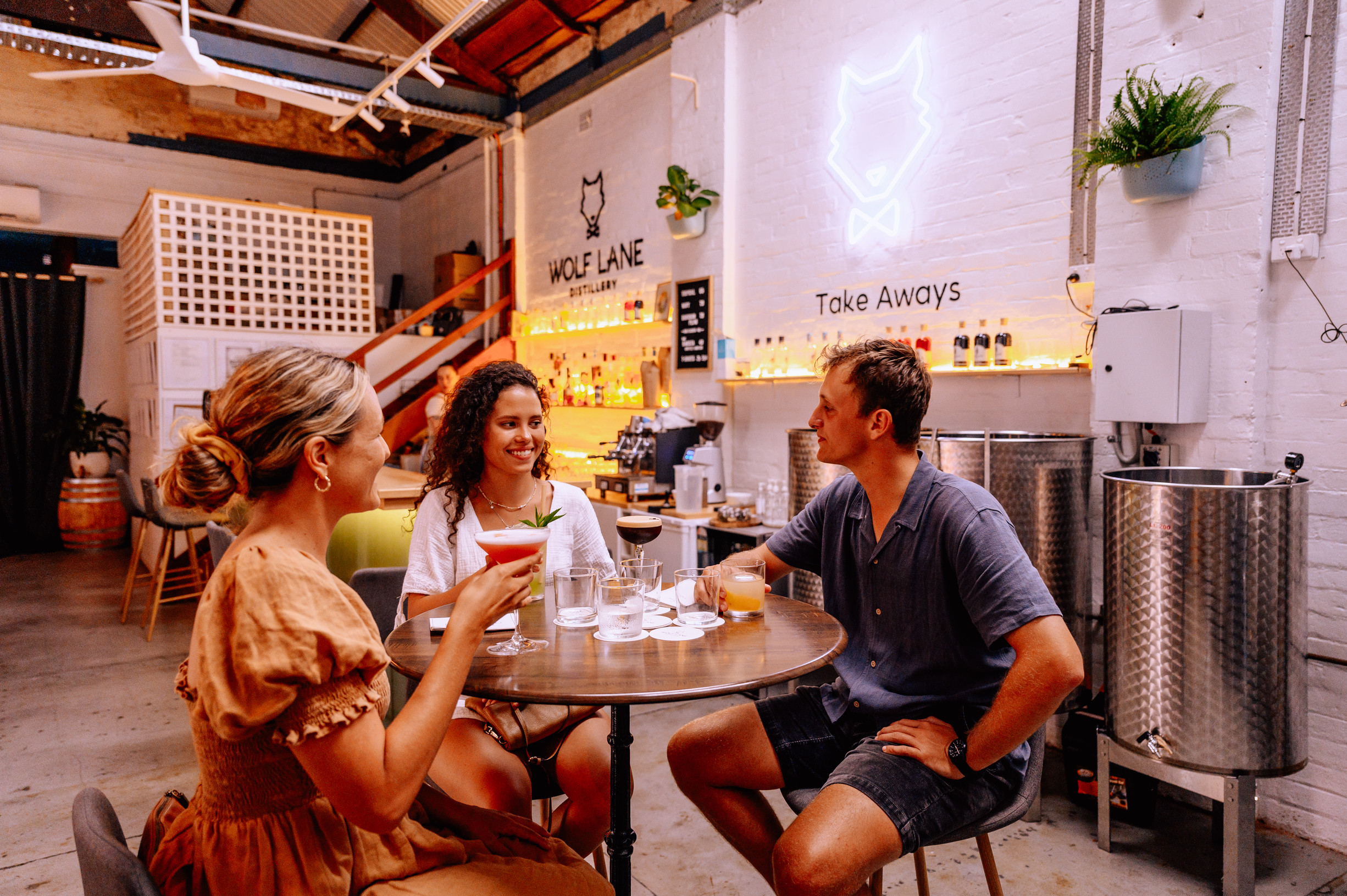 Three friends having a drink at Wolf Lane Distillery, Cairns