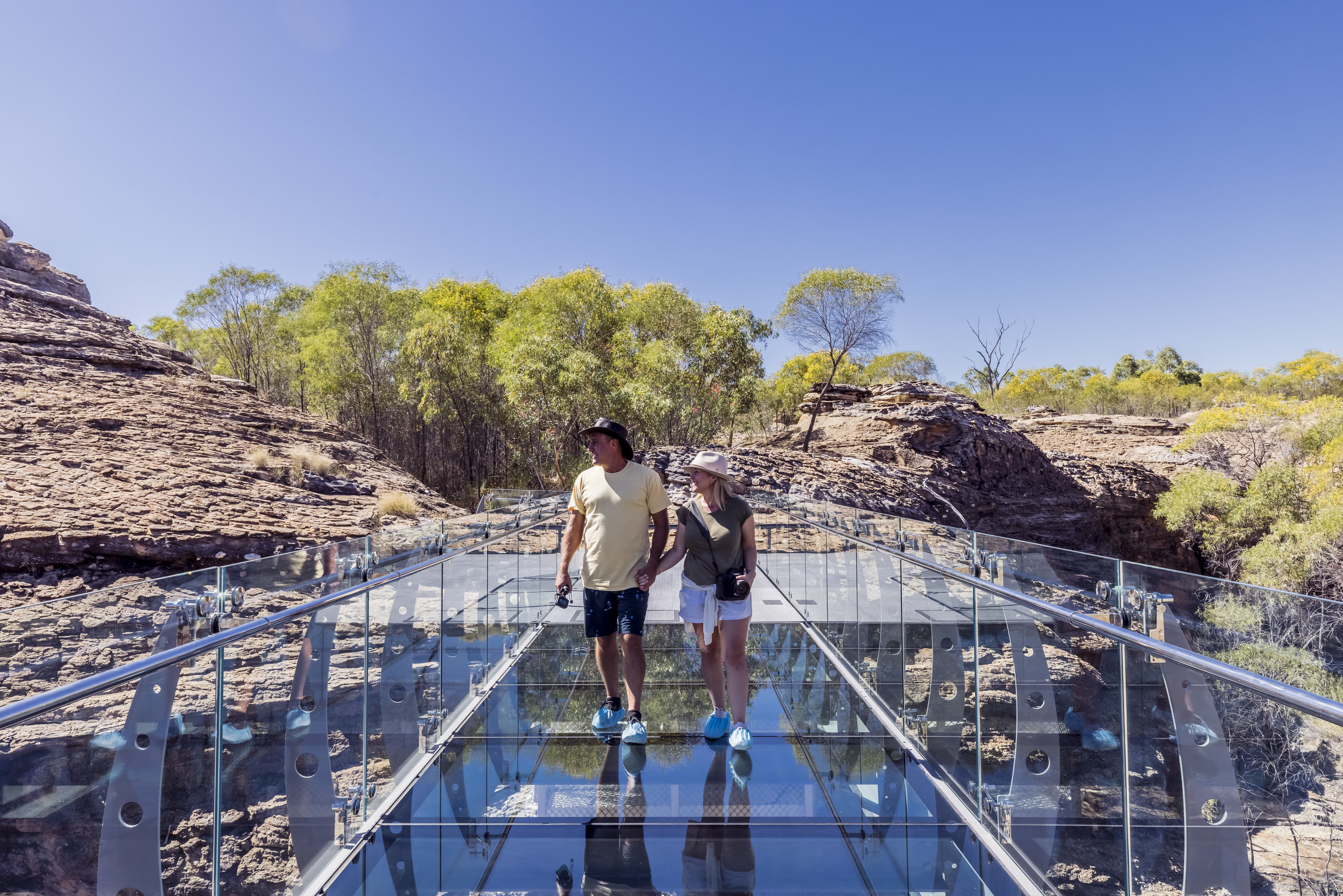 Couple walking on the Glass Bridge at Cobbold Gorge