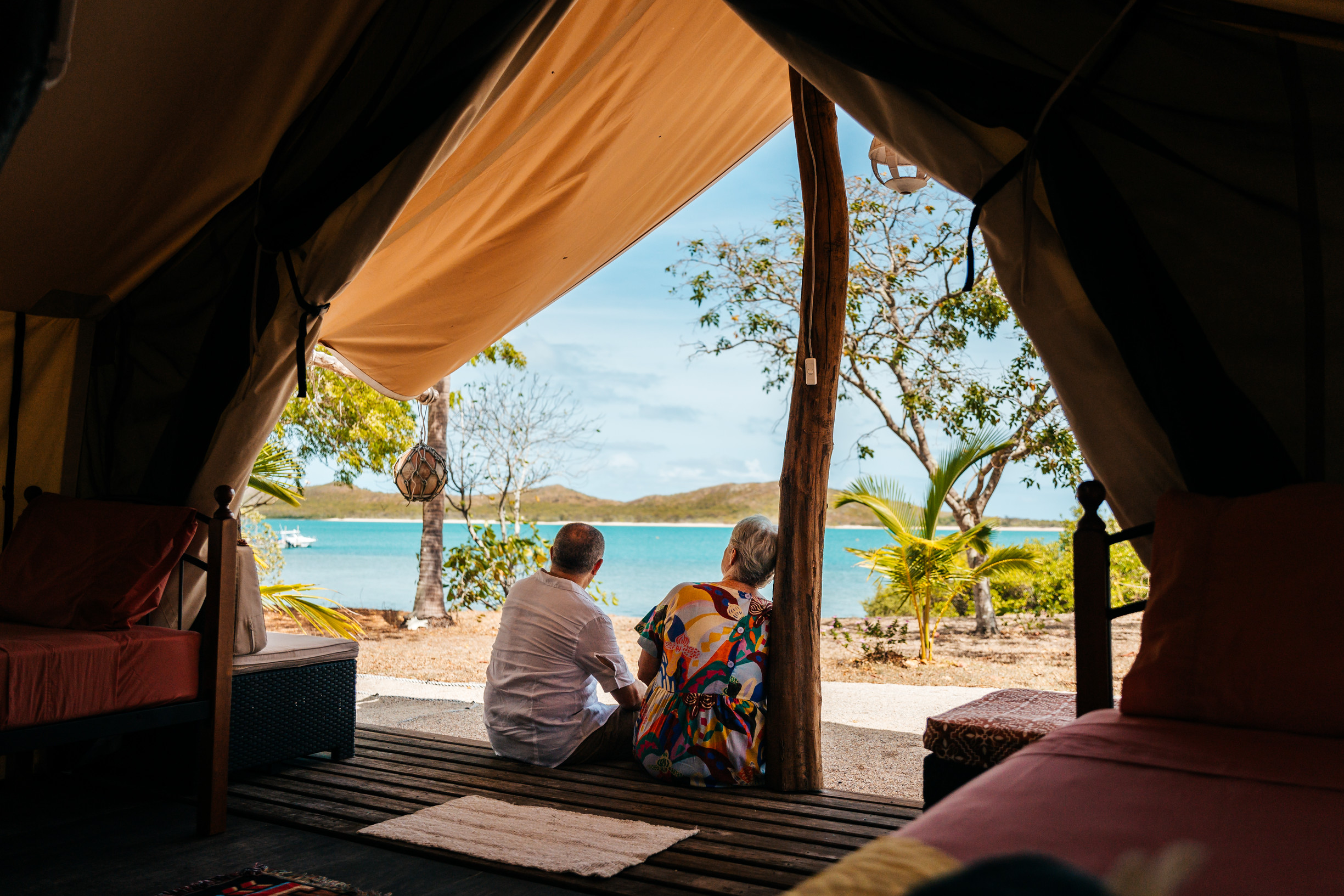 Couple sitting out the front of a glamping tent located on Roko Island, Torres Strait Couple sitting out the front of a glamping tent located on Roko Island, Torres Strait