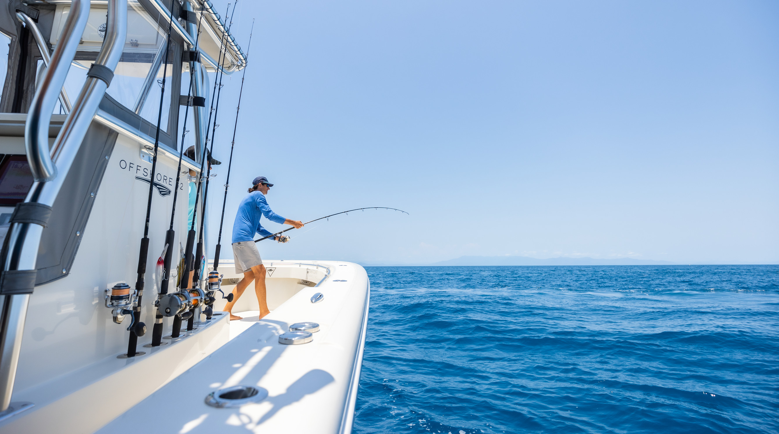 Man reeling in his rod, while on a fishing charter