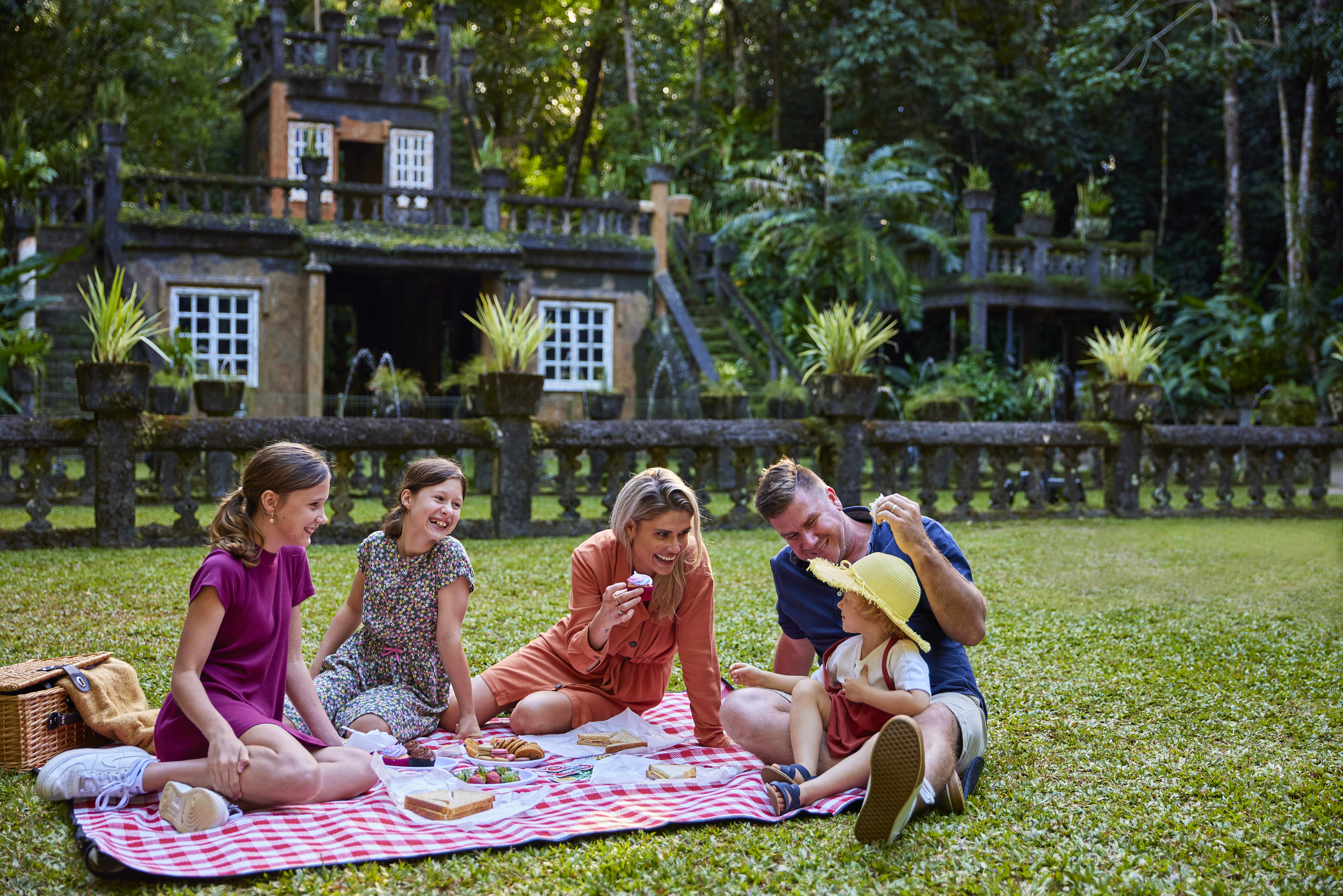 Family enjoying a picnic in front of the main castle area at Paronella Park, near Cairns Family enjoying a picnic in front of the main castle area at Paronella Park, near Cairns