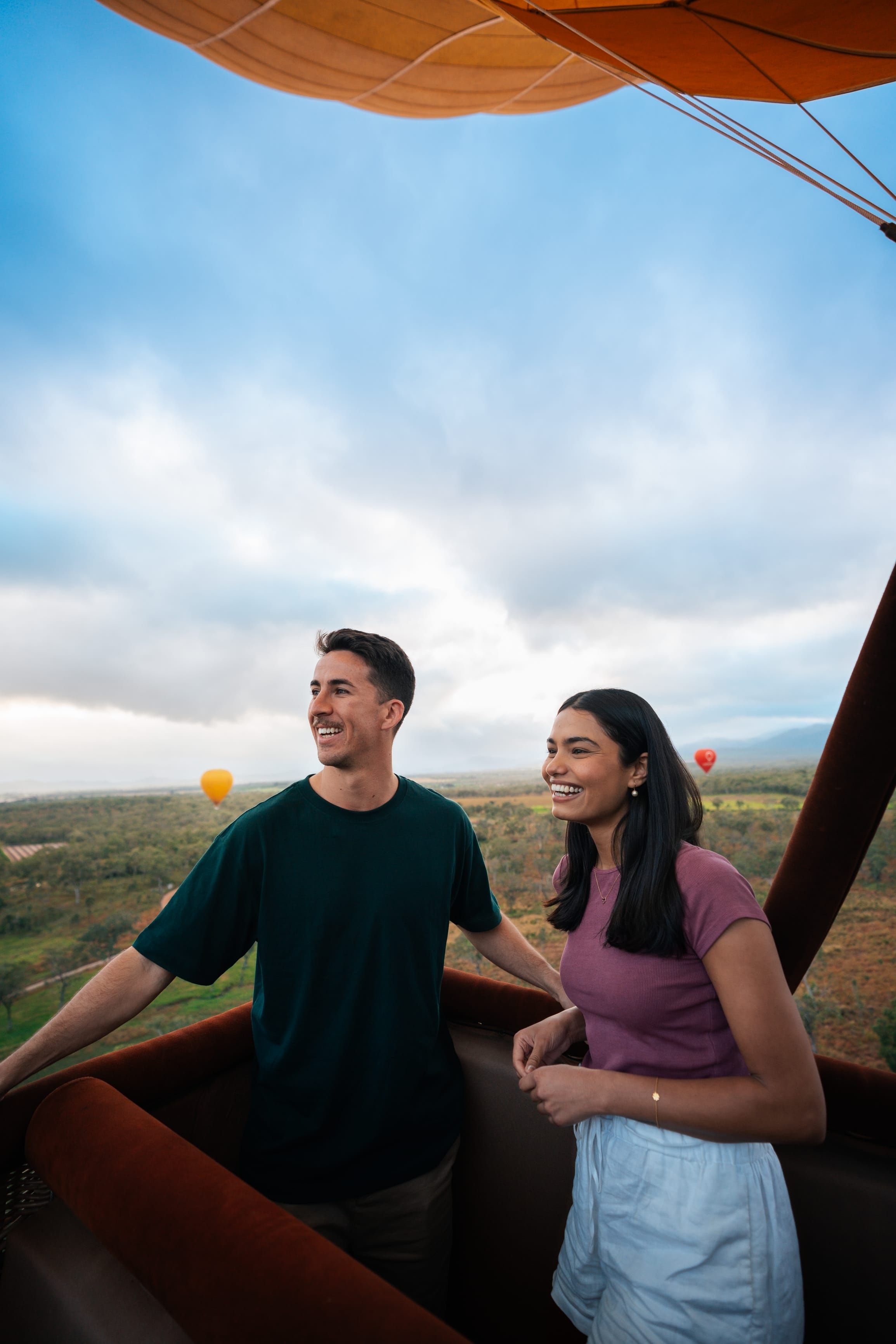 Couple enjoying a hot air balloon at sunrise high above the Atherton Tablelands
